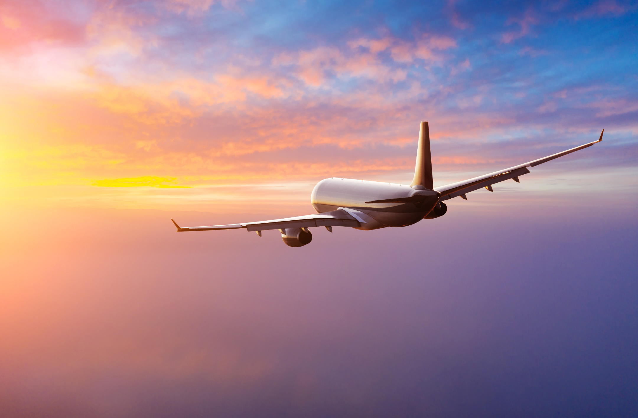 Airplane flying through vibrantly colored sky - Travel within the US