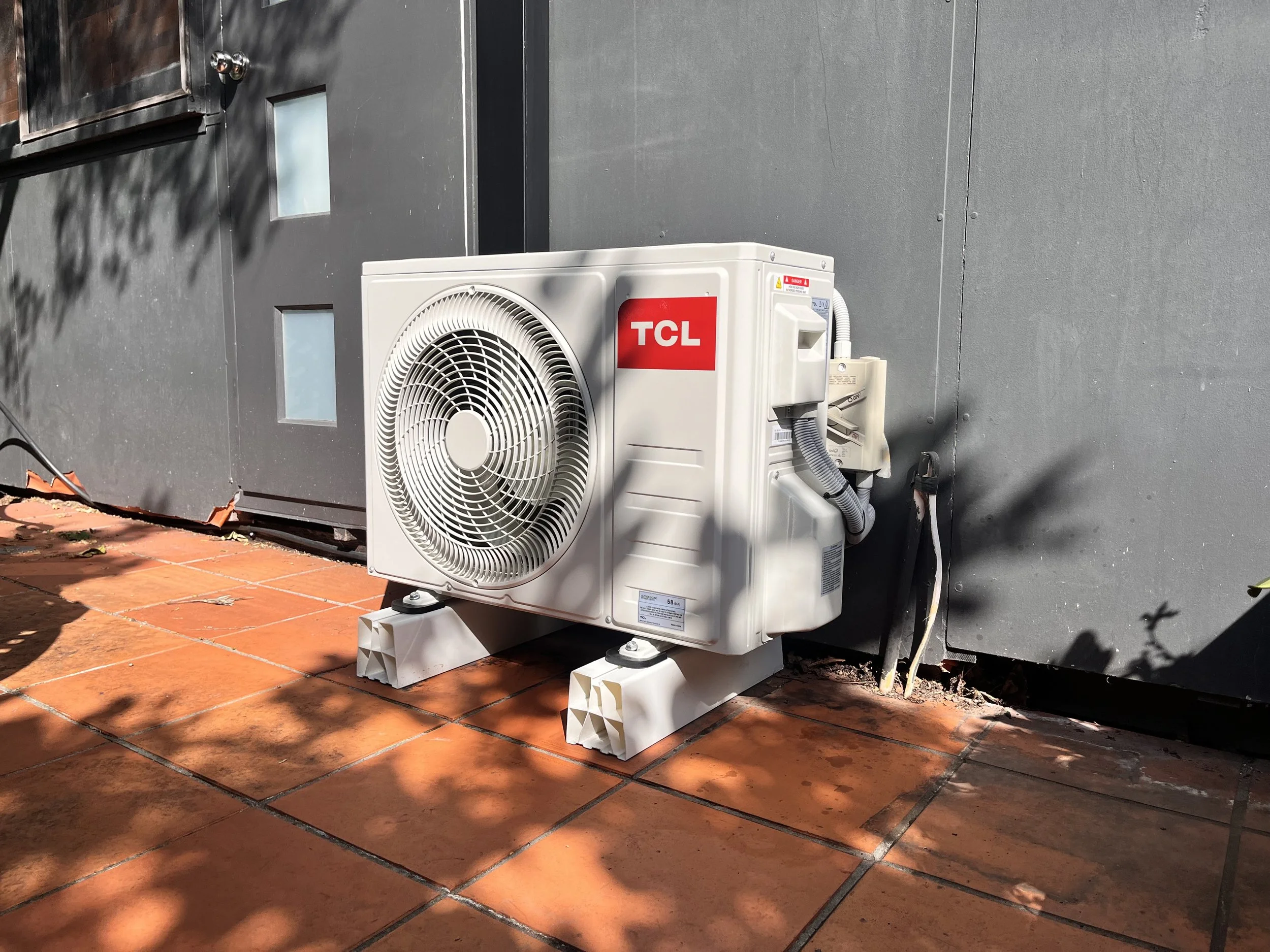 TCL split system outdoor unit on a tiled terrace