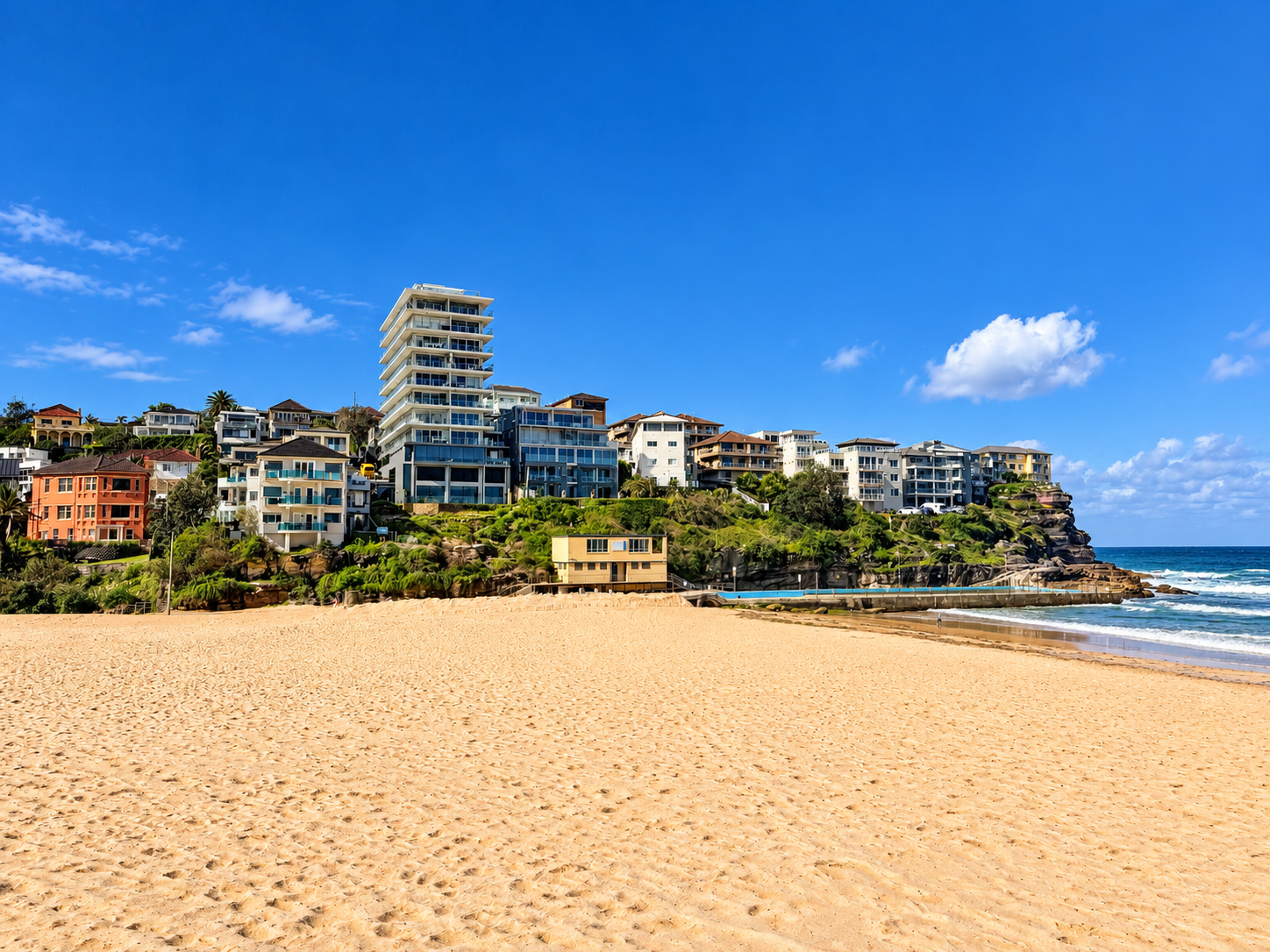 Photo of a Sunny Coastal Beach with Cliffside Apartments