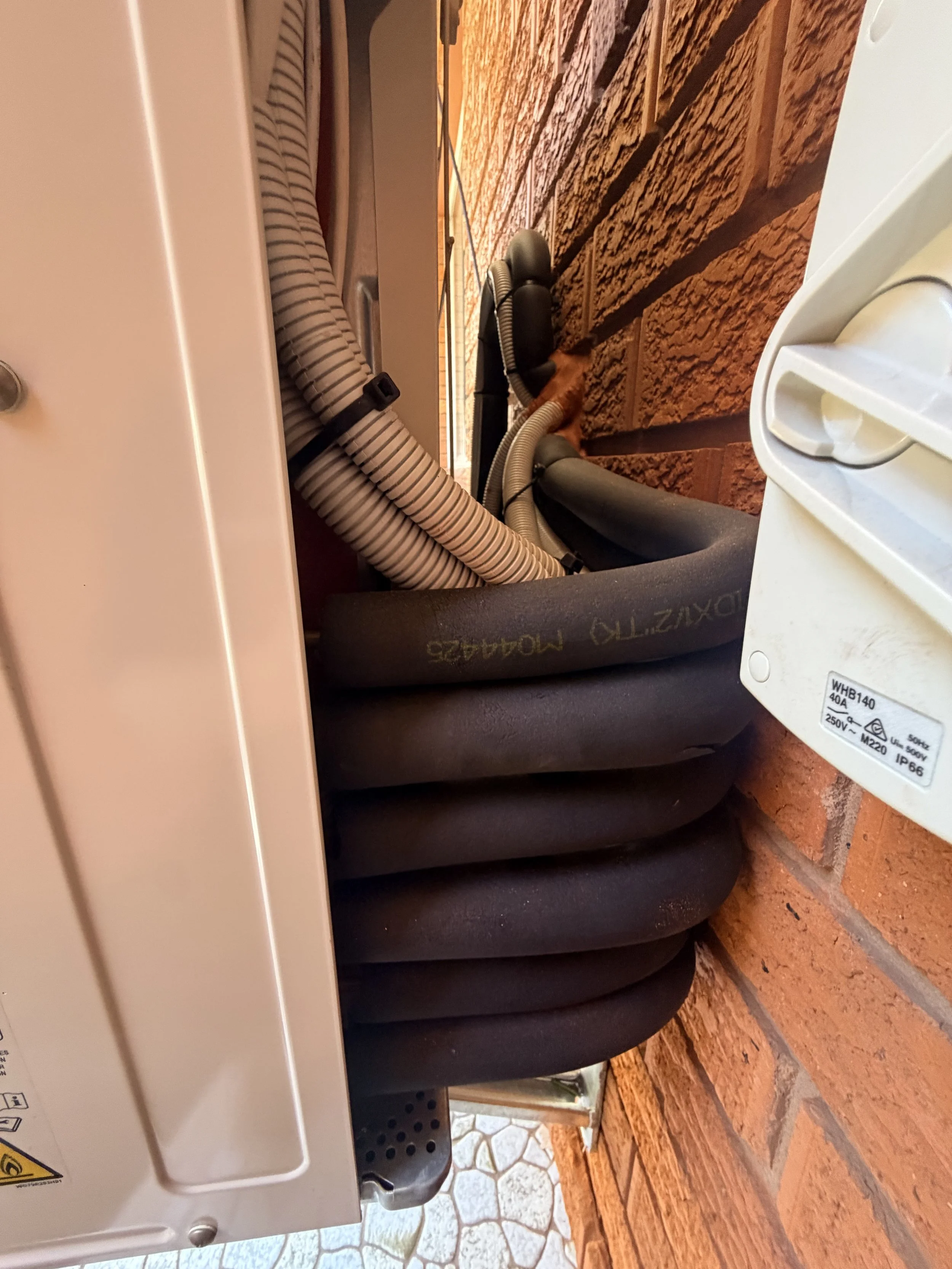 a picture showing the pipe connections of a multisplit ac behind the outdoor unit