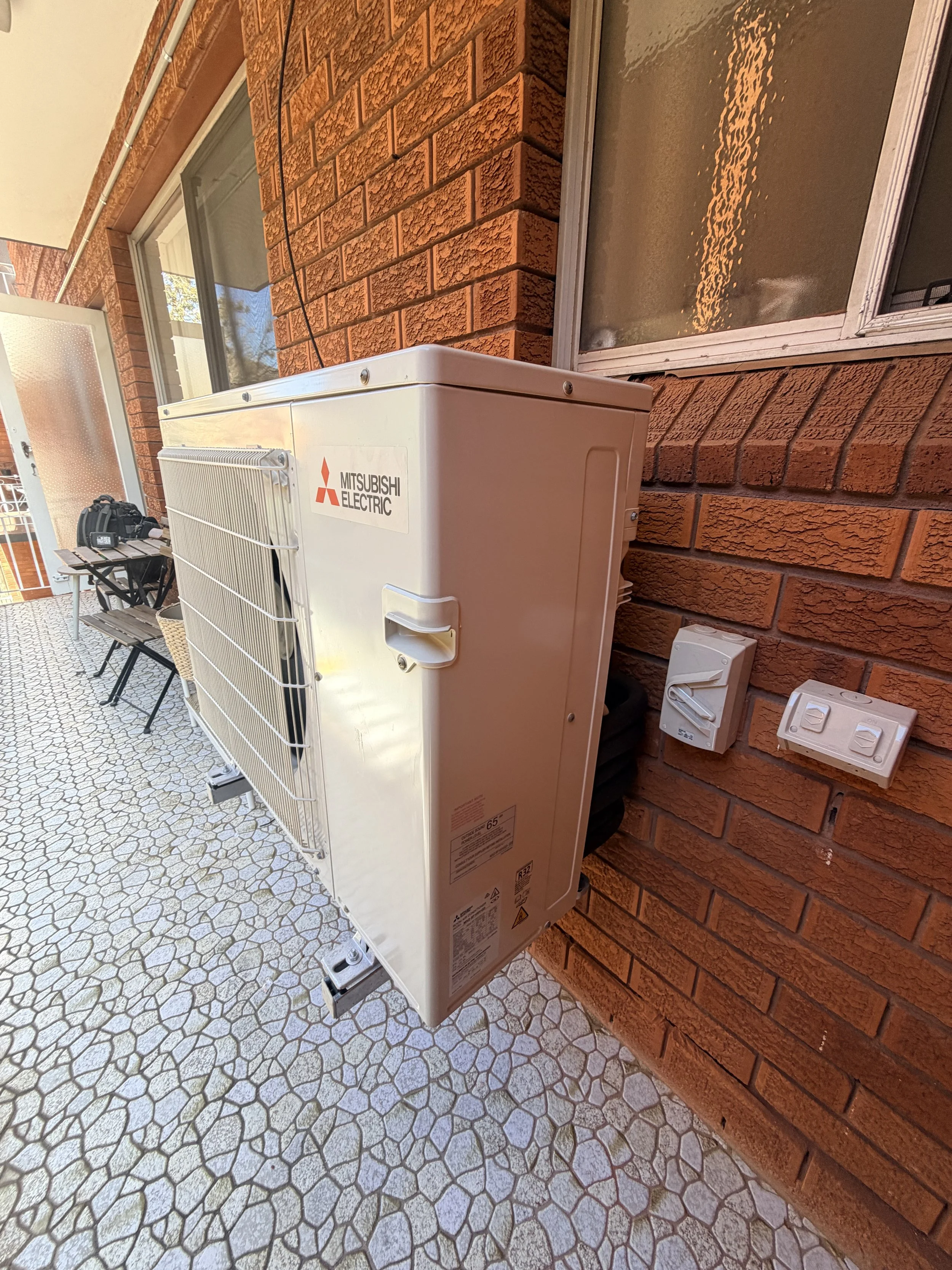 a picture showing an air con outdoor unit on a balcony in artarmon