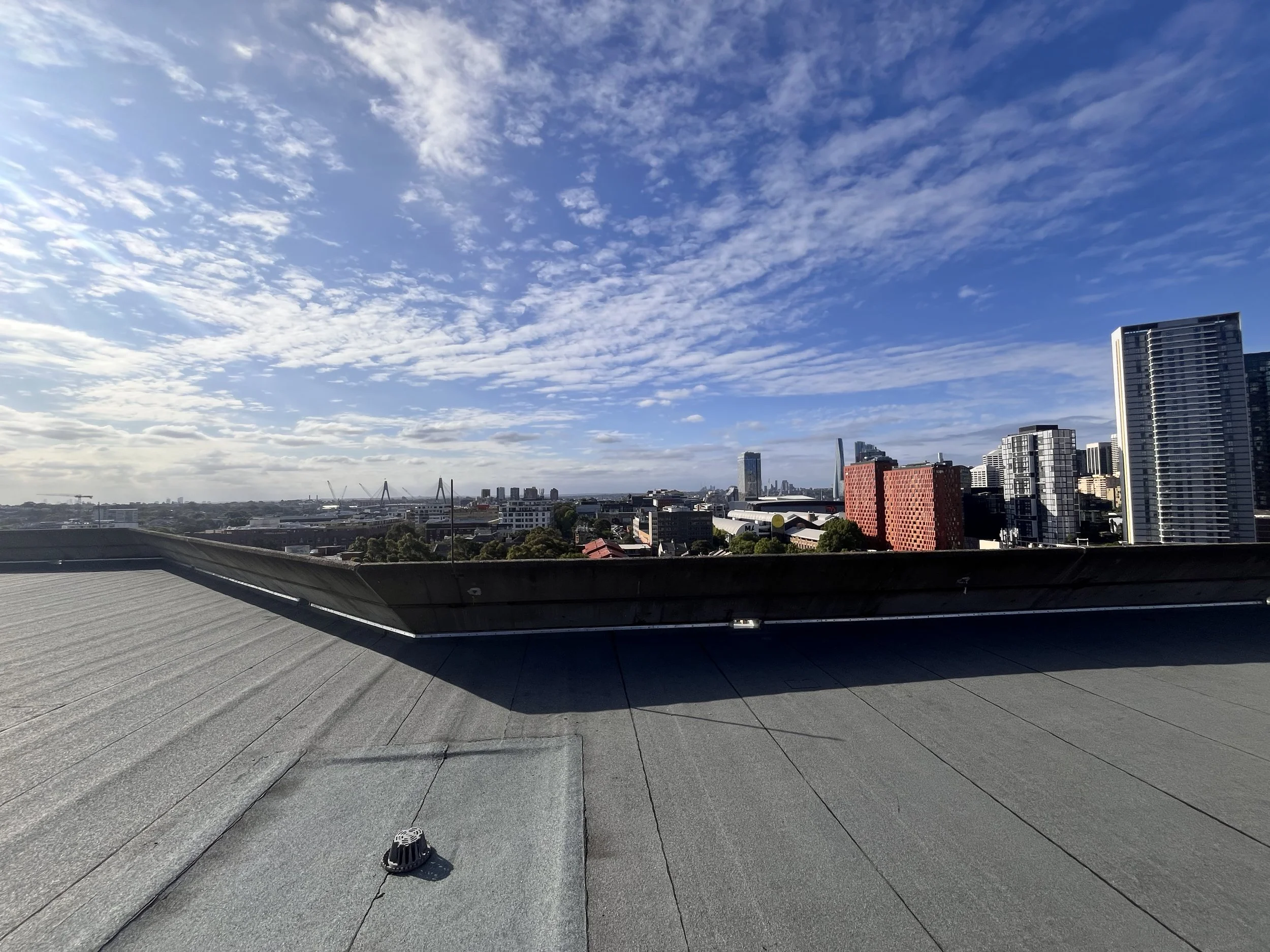 Rooftop of an inner city apartment building with high-rise towers behind