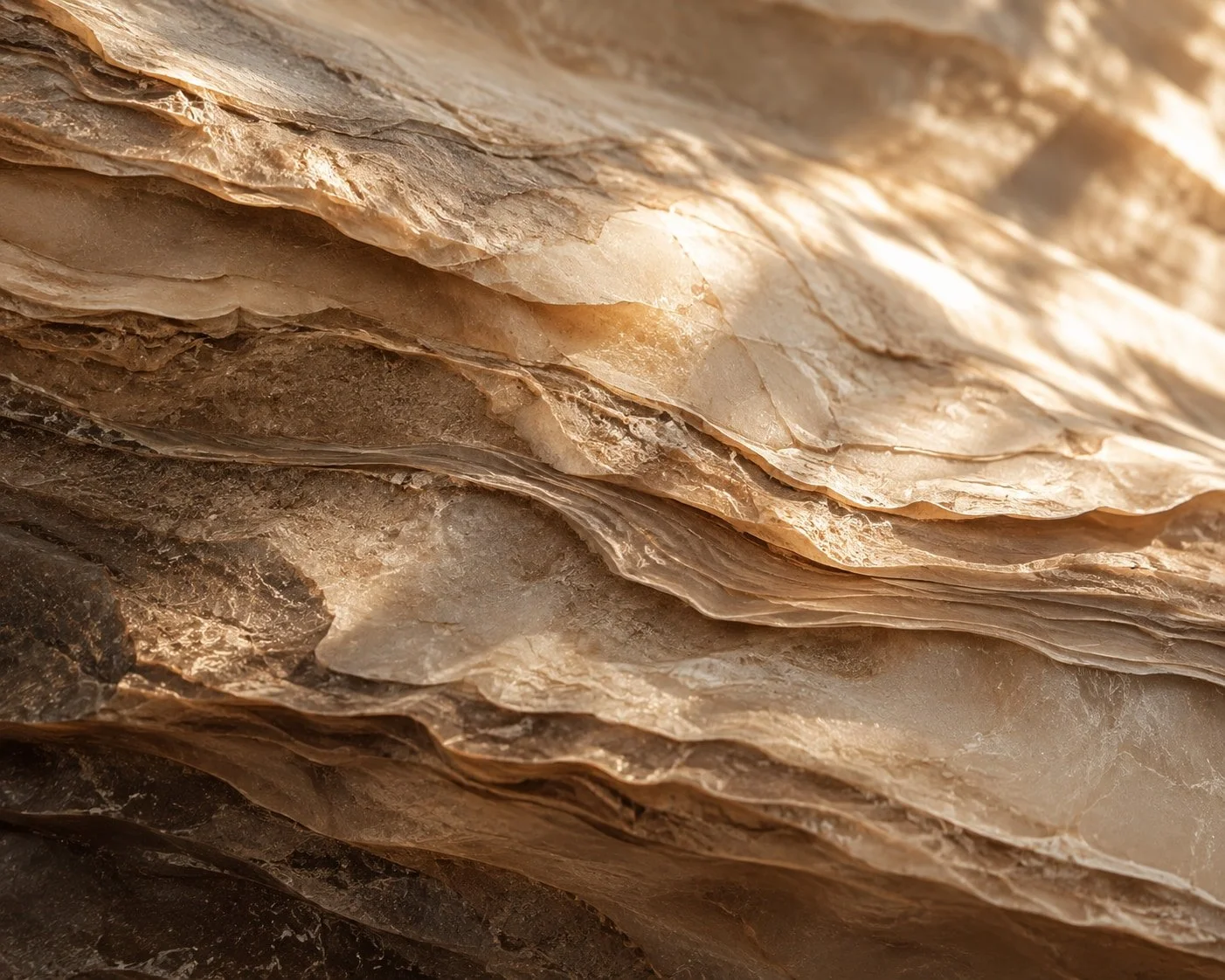 Close-up view of layered sandstone rocks with varying shades of beige, brown, and tan.
