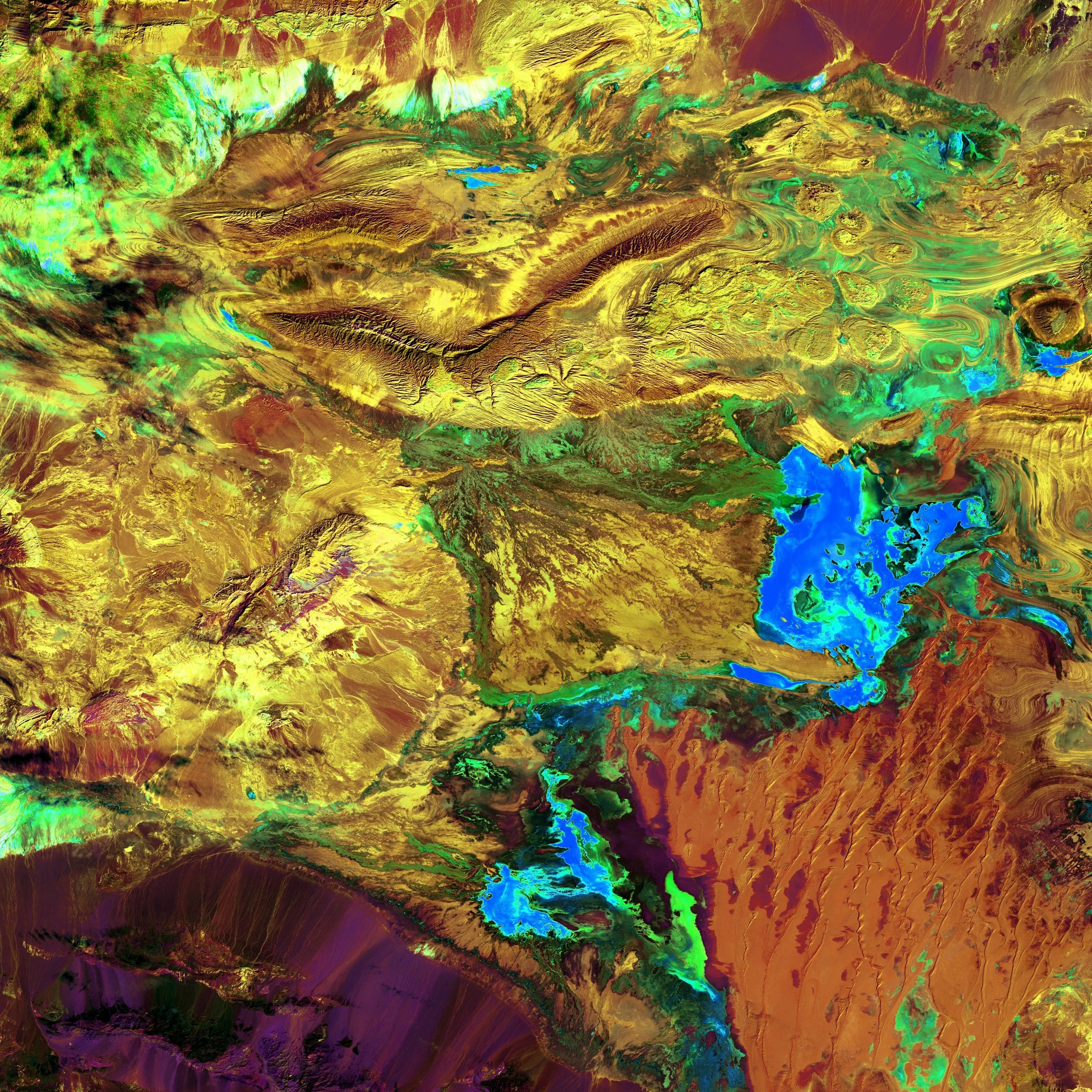 A colorful abstract painting with swirling patterns in green, blue, yellow, purple, and gold hues.