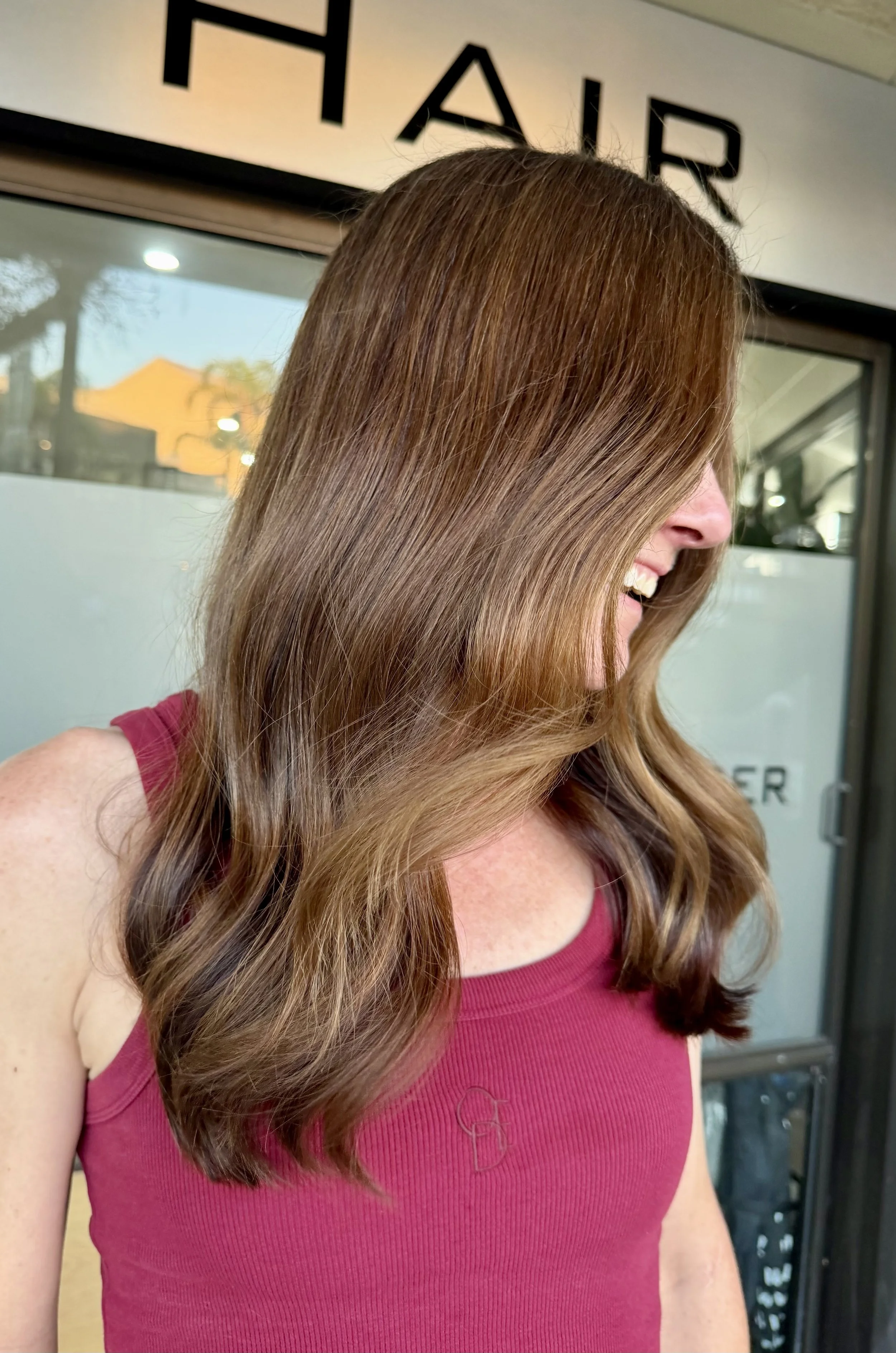 Long brown wavy hair after a grey blending service at Janos Kiss Hair, Cremorne
