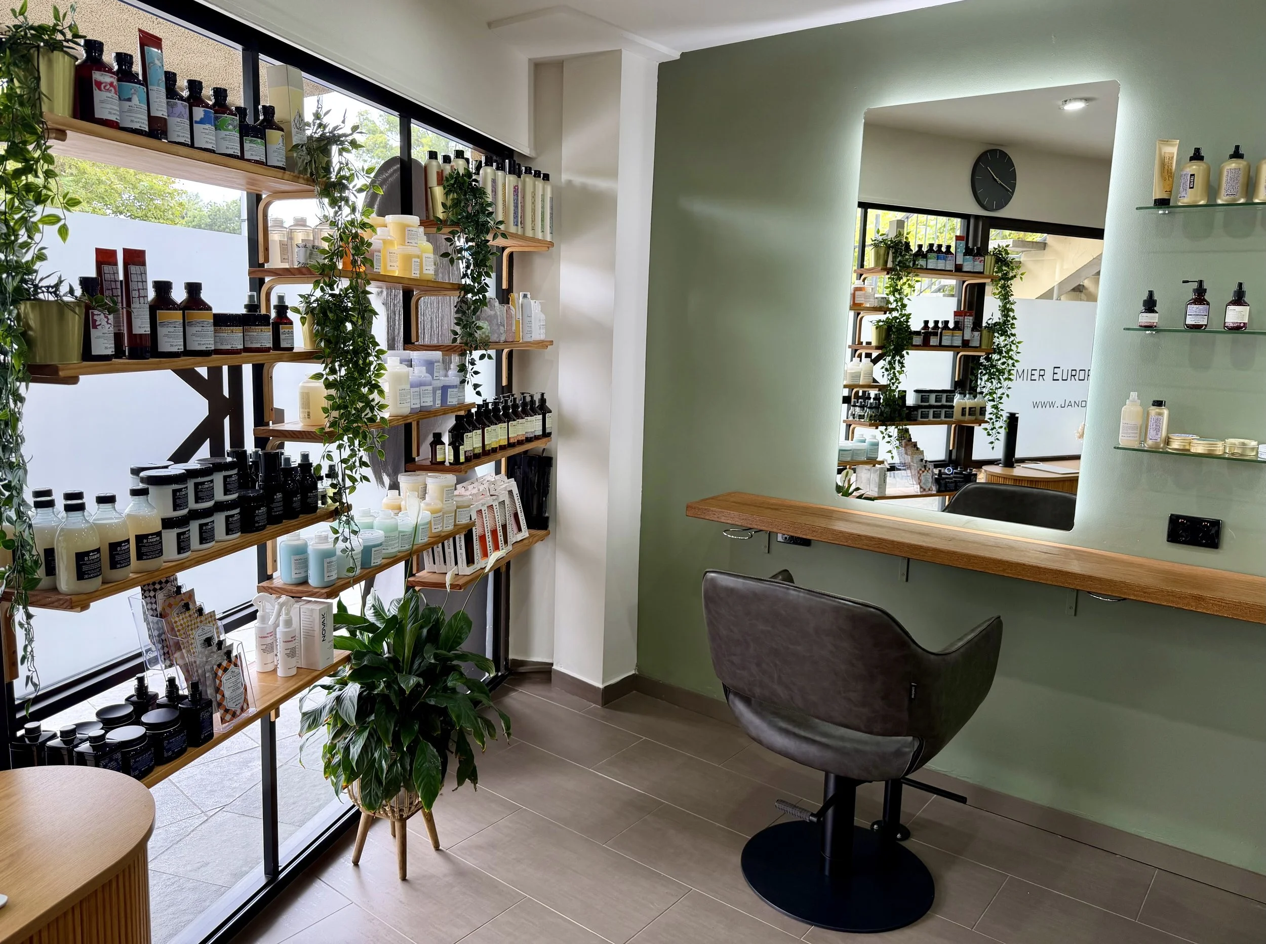 Davines retail shelves and a styling chair by the window at Janos Kiss Hair, a boutique salon in Cremorne, Sydney