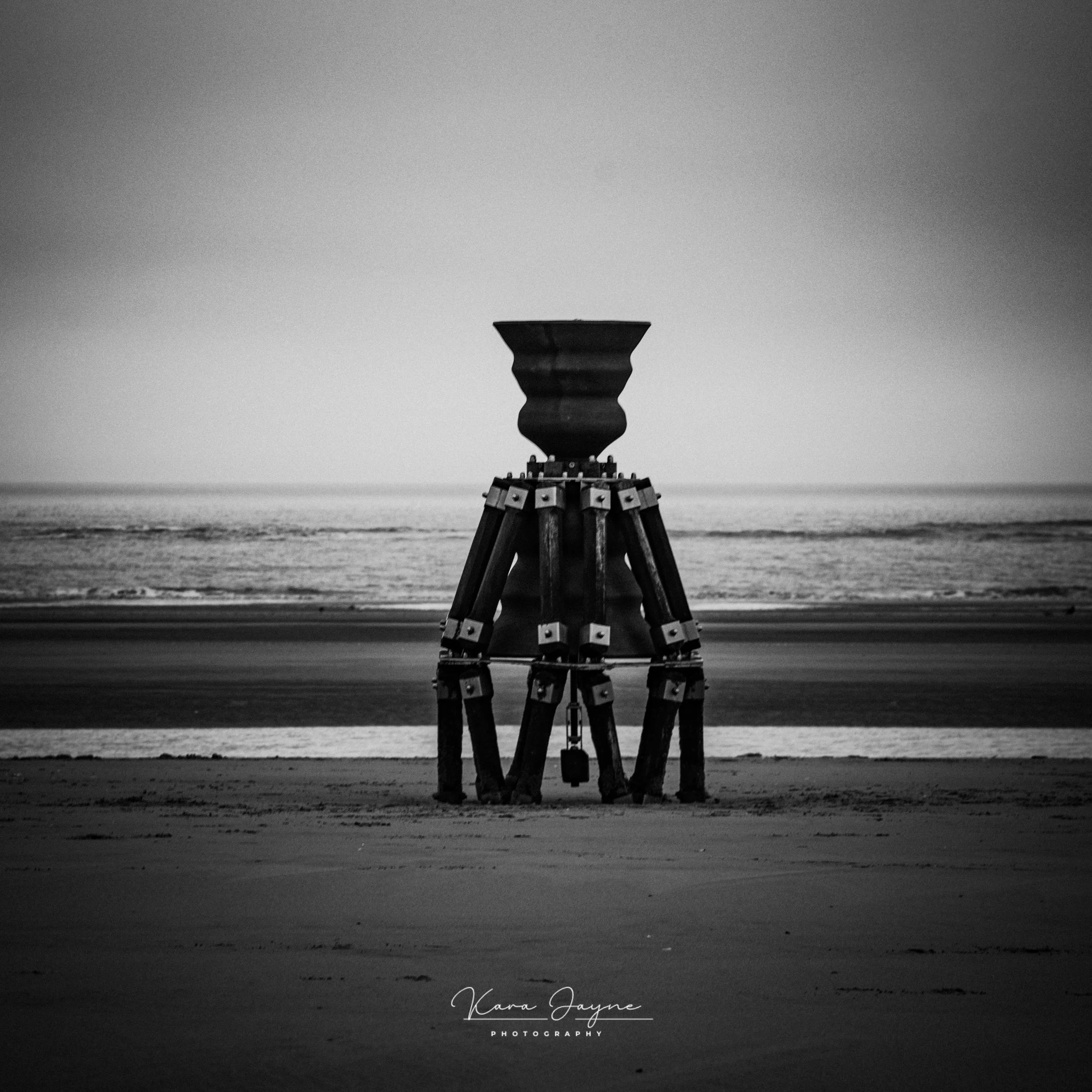Black and white photo of a lighthouse by the ocean, with text 'Kara Jayne Photography' at the bottom.