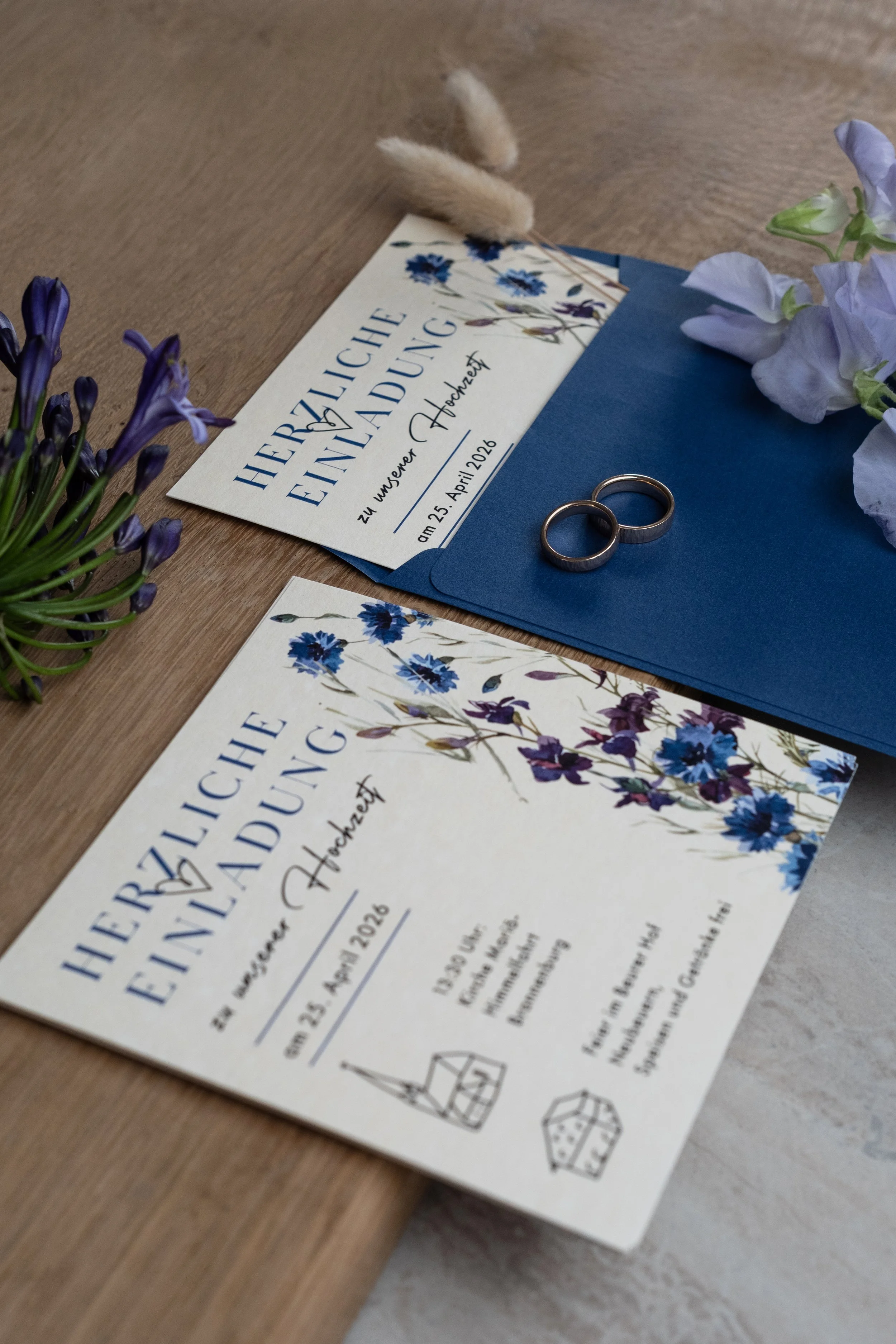 Schöne individuelle Hochzeitseinladungen und passende Papeterie in einem blauen Umschlag.