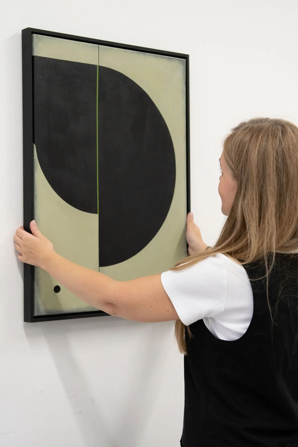 Simona Puidokaite holding a black abstract painting