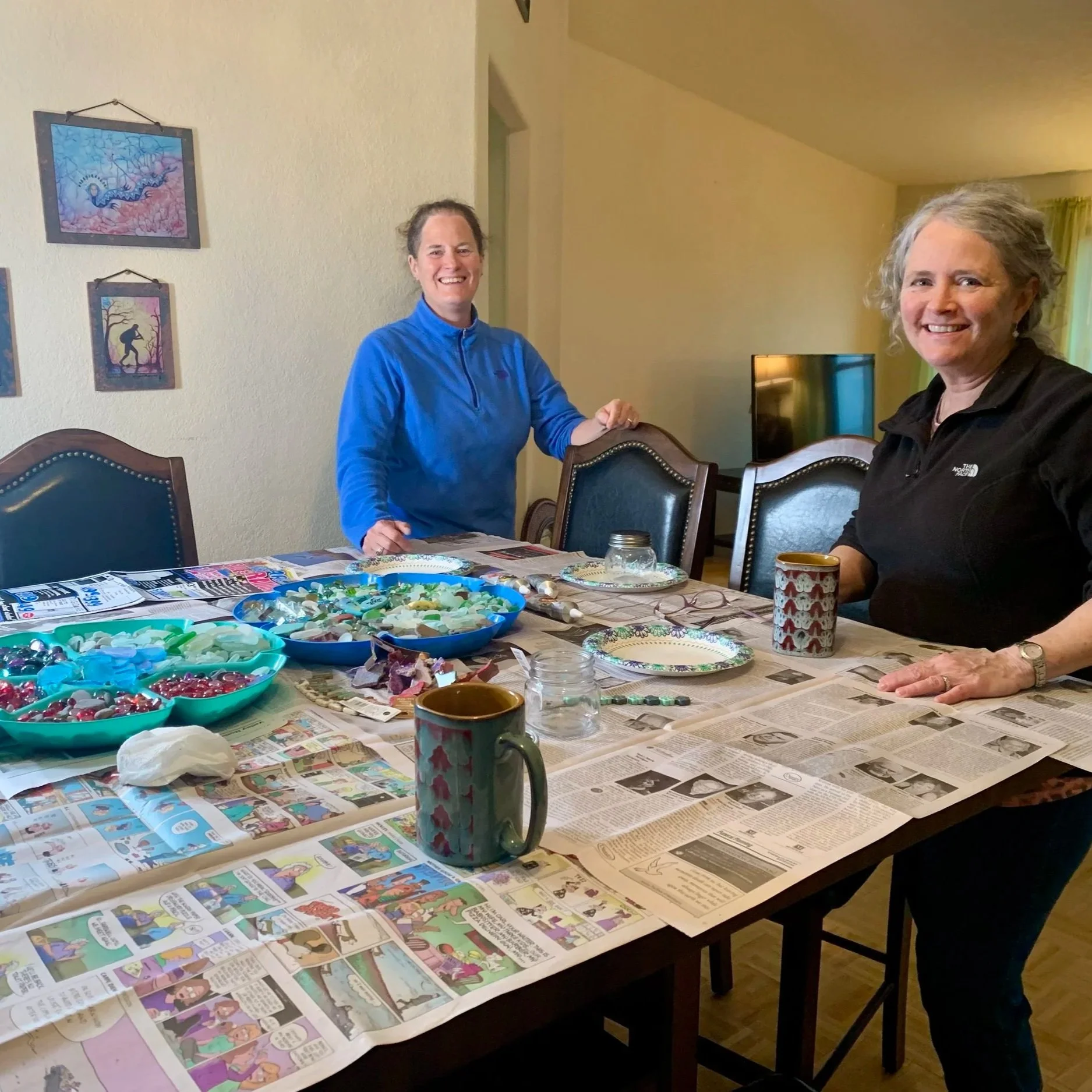 Terrie and her sister making sea glass, bead, and copper jewelry at a table.
