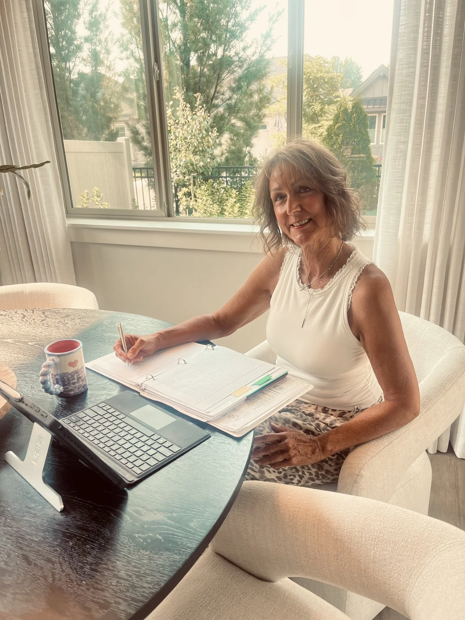 Marlene Tapie working with client paperwork at her dining table.