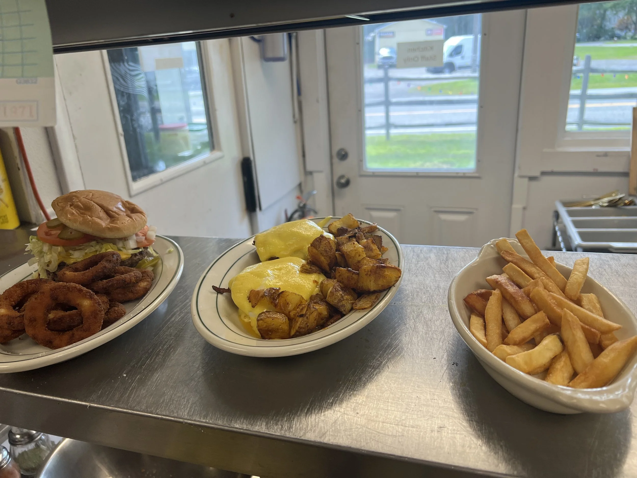 Three lunch plates on the counter at Royal Diner, including a burger with lettuce and tomato