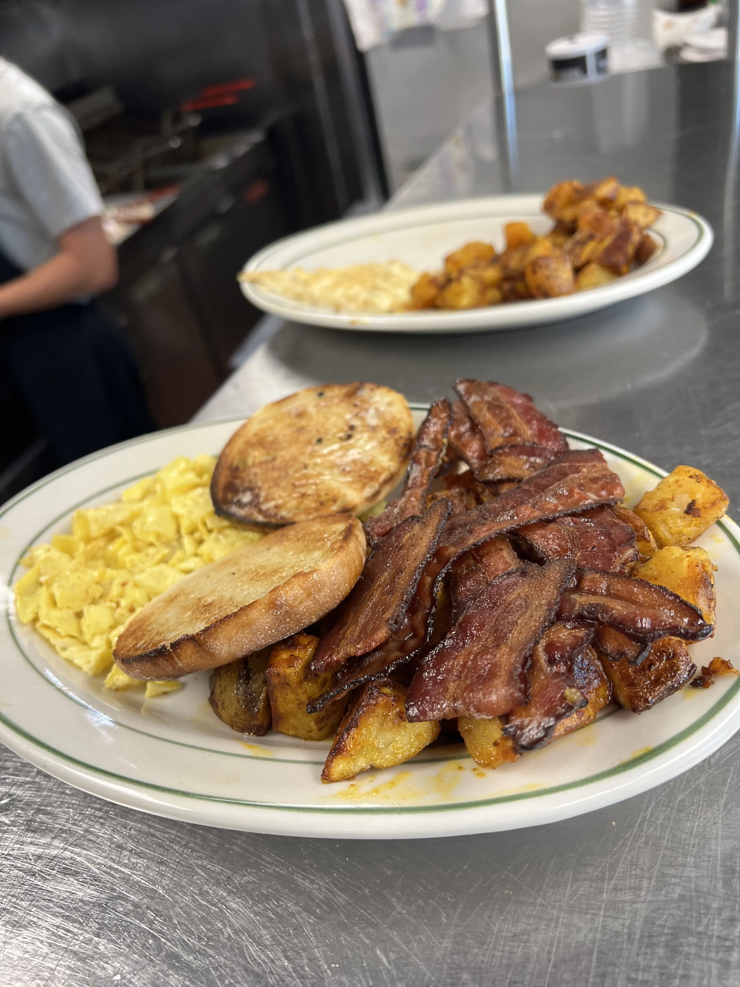 Breakfast plate with scrambled eggs, English muffin, bacon and roasted potatoes at Royal Diner