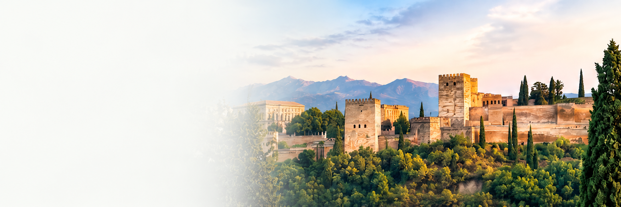 View of the Alhambra palace and fortress complex in Granada, Spain, with mountains in the background and lush green trees in the foreground during sunset.