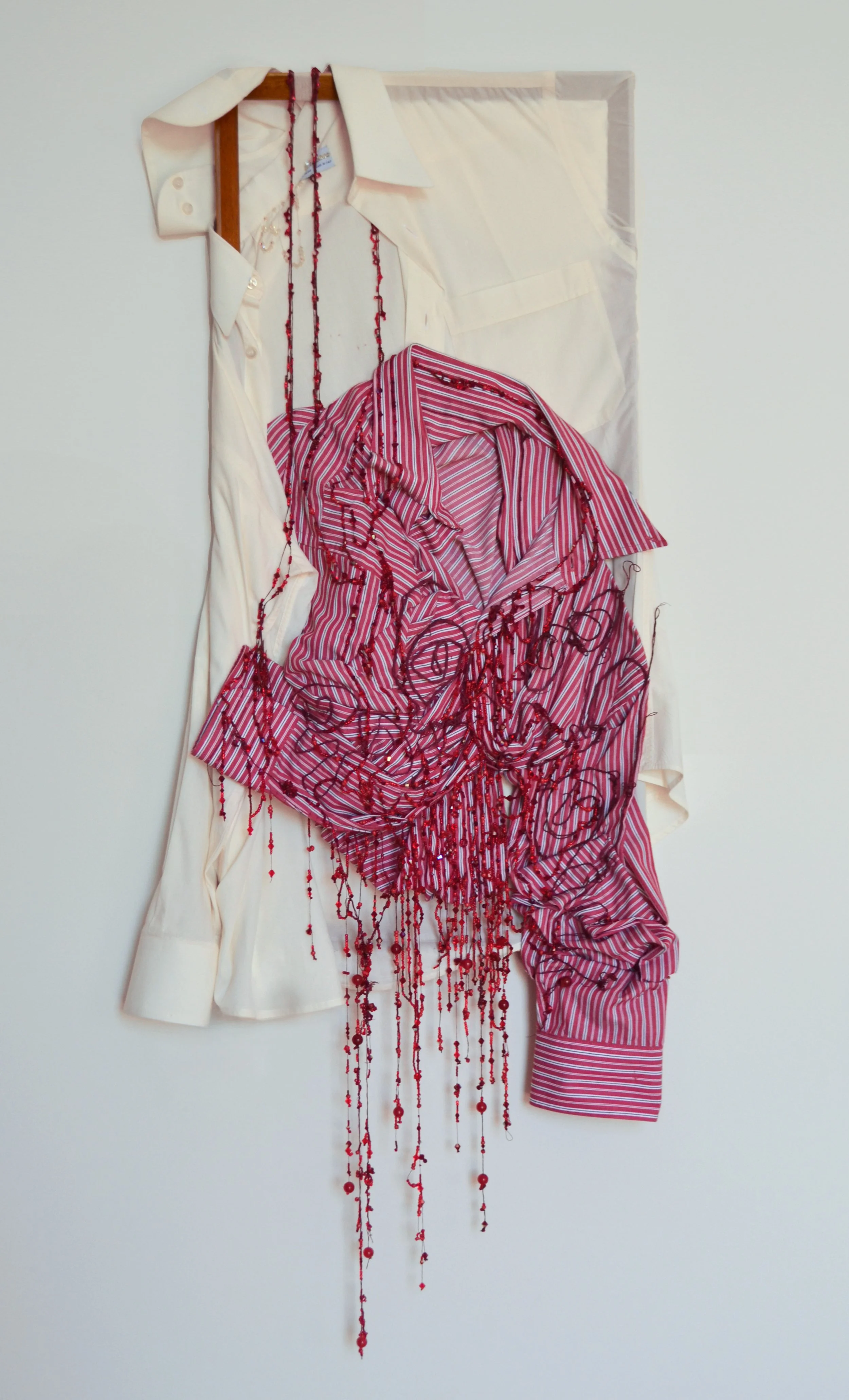 No Me Dejes (Don’t Leave Me), 2026. 31.5” x 24”. Secondhand 100% cotton button-down shirts, hand-painted cotton canvas threads, crystal beads, glass beads, and reclaimed wood frame