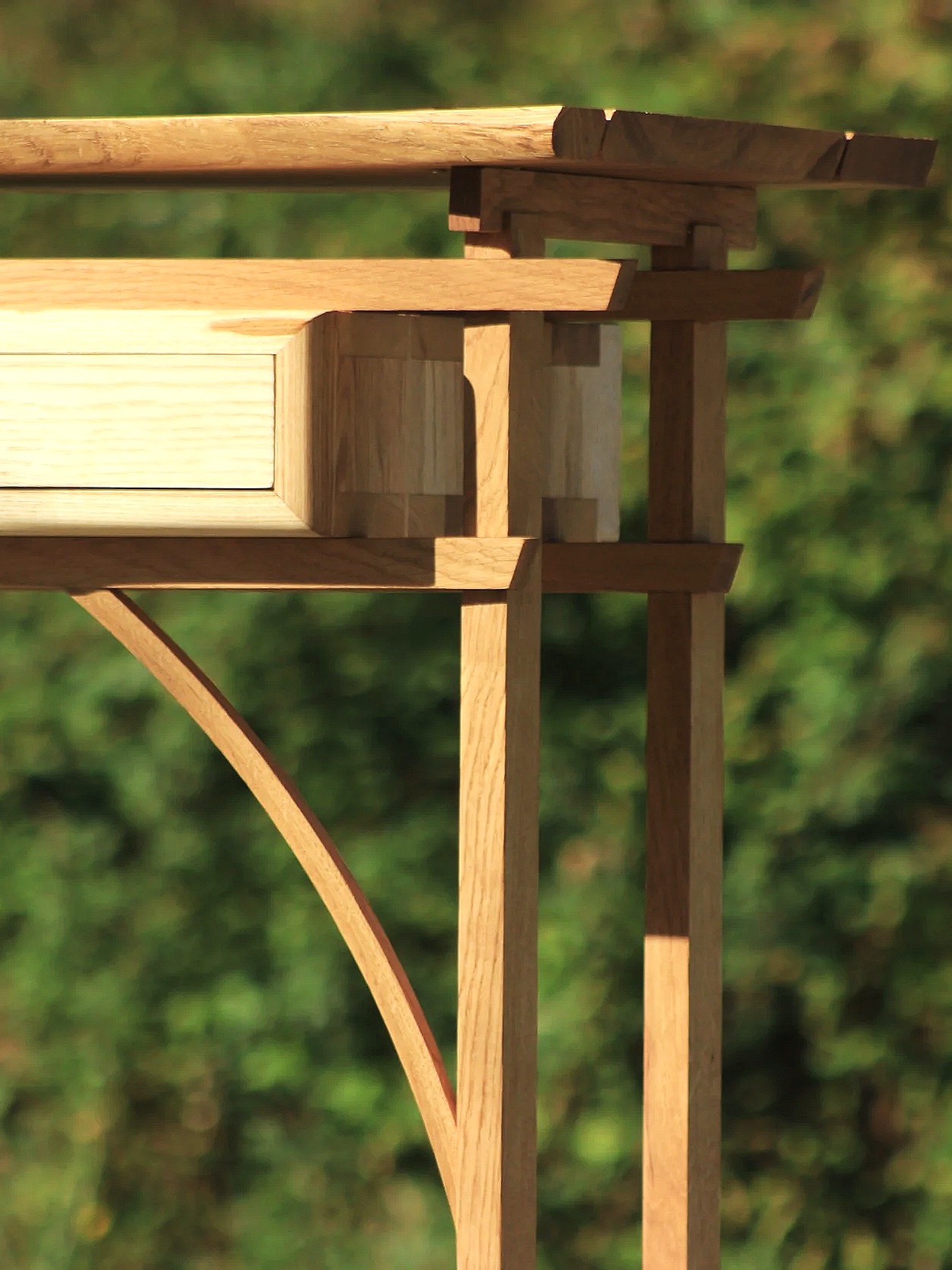 Une structure en bois composite de différentes planches et poutres formant une construction architecturale, avec un fond de végétation verte floue.