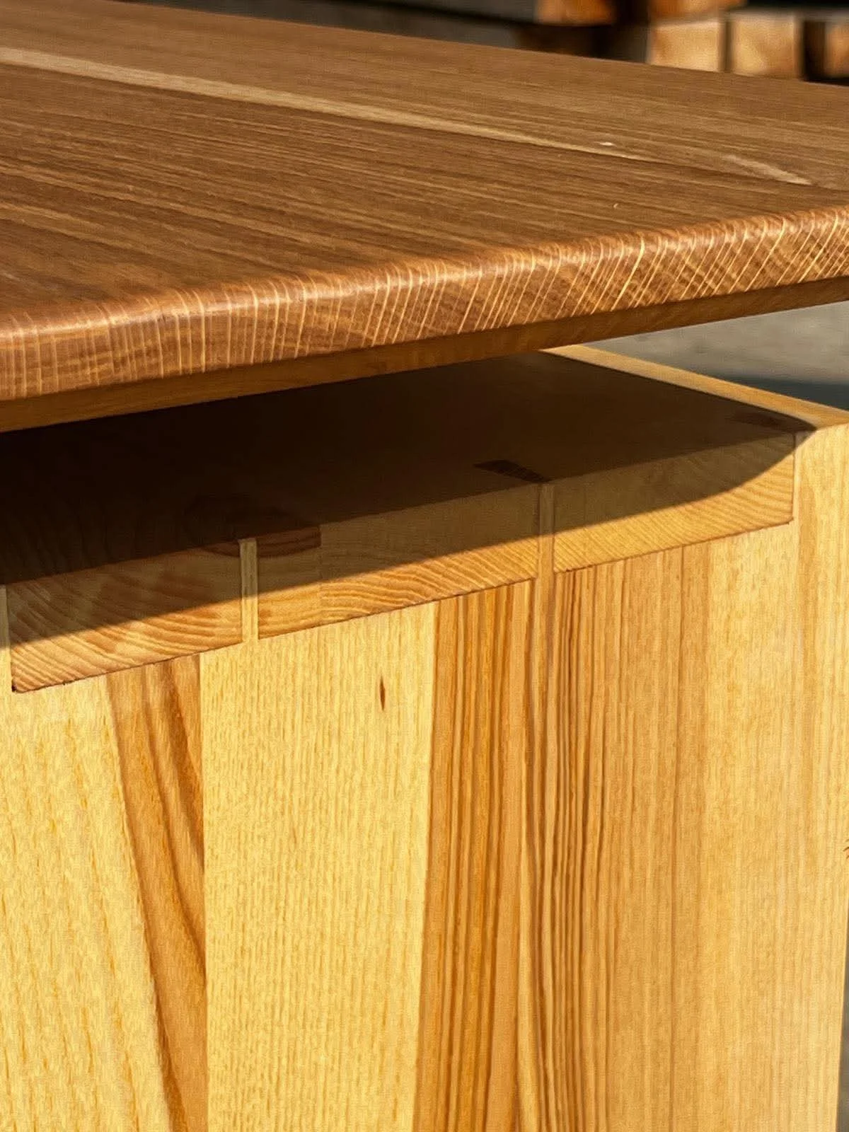 meuble en bois clair avec un tiroir ouvert, laissant apparaître un espace de rangement intérieur