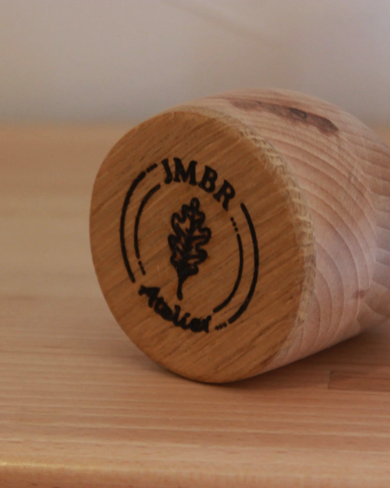 Bouchon en bois avec un logo gravé représentant un arbre et le texte 'IMBR' et 'HS'