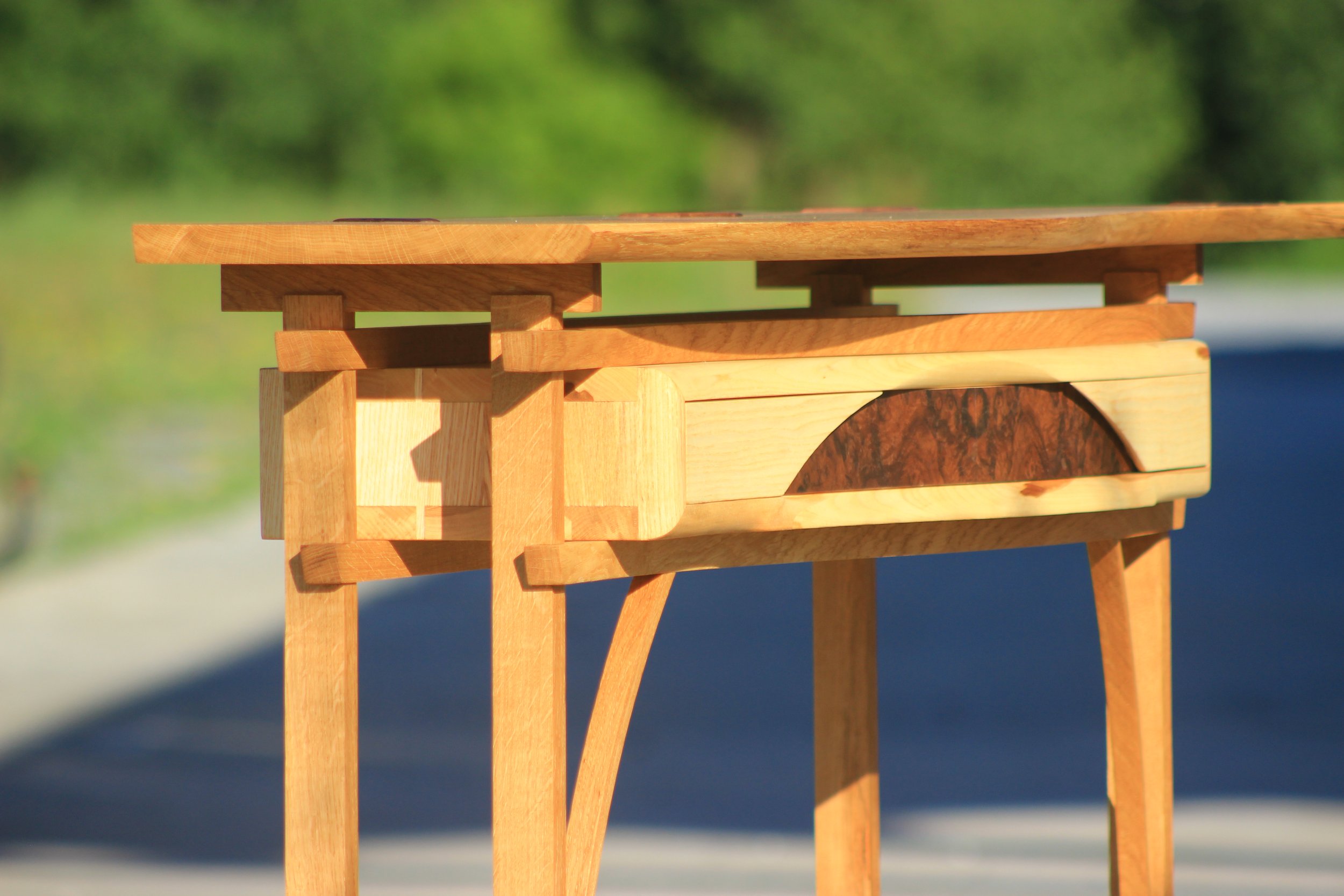 Table en bois en plein air avec un fond de nature verdoyante.