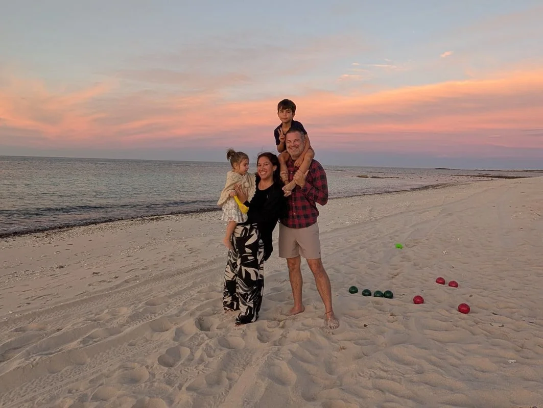 Shane, Karen, and their children on a beach at sunset