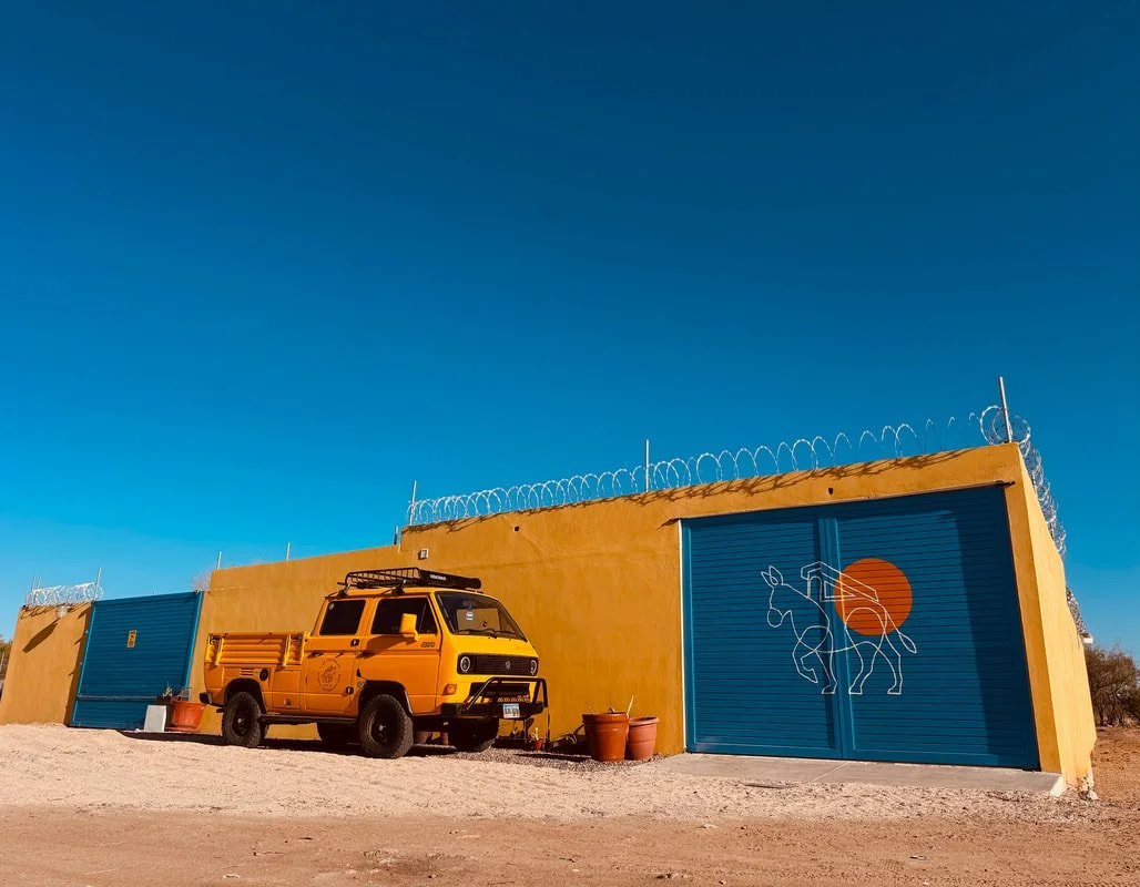 Yellow Volkswagen Syncro Doka outside the LiveTheVanLife restoration workshop in La Paz, Mexico
