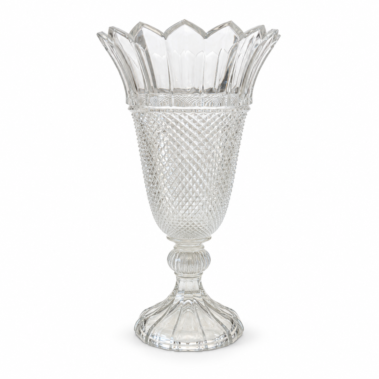 Clear glass pedestal vase with a diamond-textured body and pointed scalloped rim on a white background.