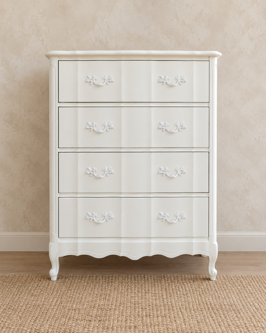 Tall French Provincial-style chest of drawers refinished in warm white with decorative white pulls and a scalloped base