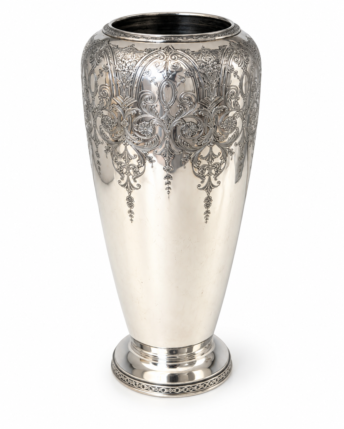 Close-up of antique silver-plated vase showing intricate floral and scrollwork engraving in the Paisley pattern.