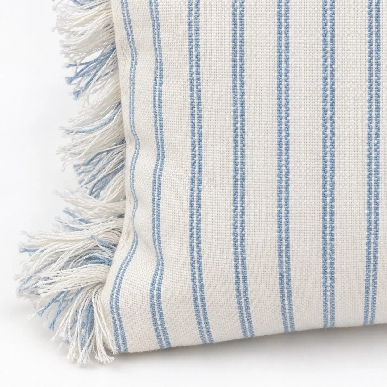 Close detail of the ticking stripes and fringed pillow edge.