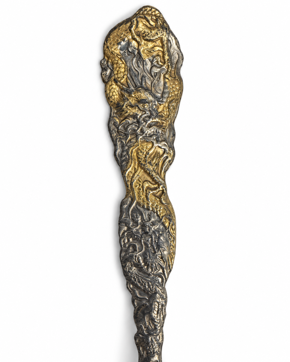 Dragon-handled World’s Fair souvenir spoon styled on ivory linen on a walnut desk.