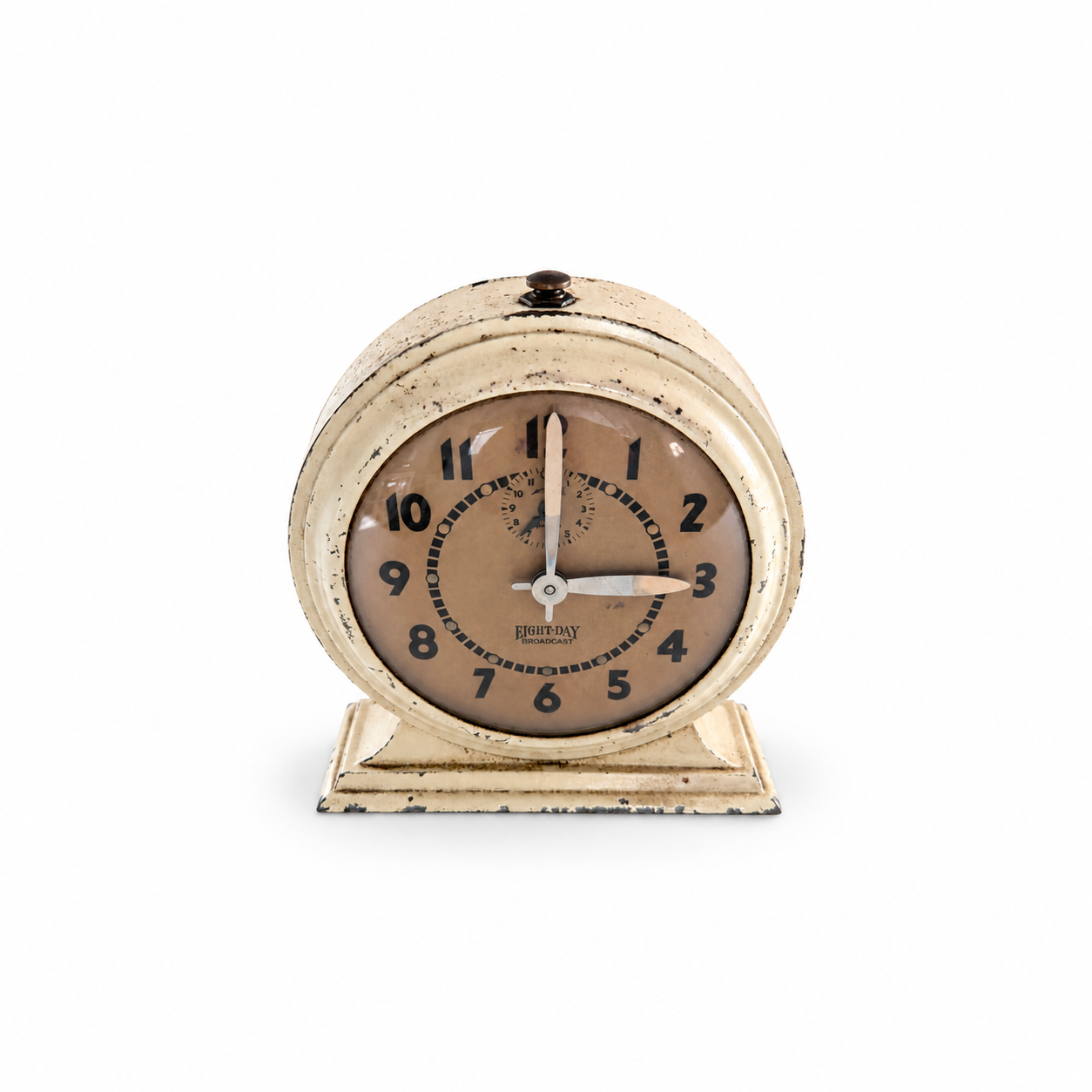 Cream Eight-Day Broadcast clock with black numerals, an aged dial and chipped paint on a white background.