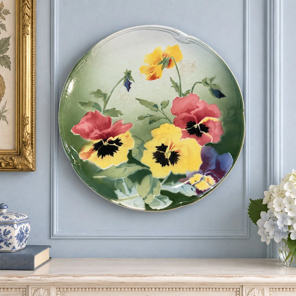 French pansy plate on a pale-blue wall above a painted console.