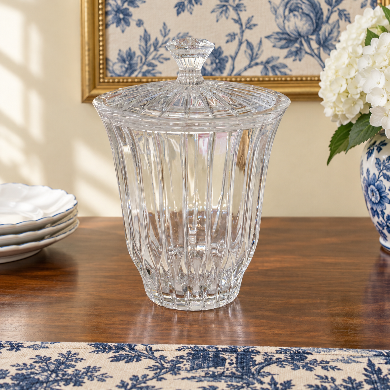 Clear lidded crystal jar showing its curved sides and vertical fluting.