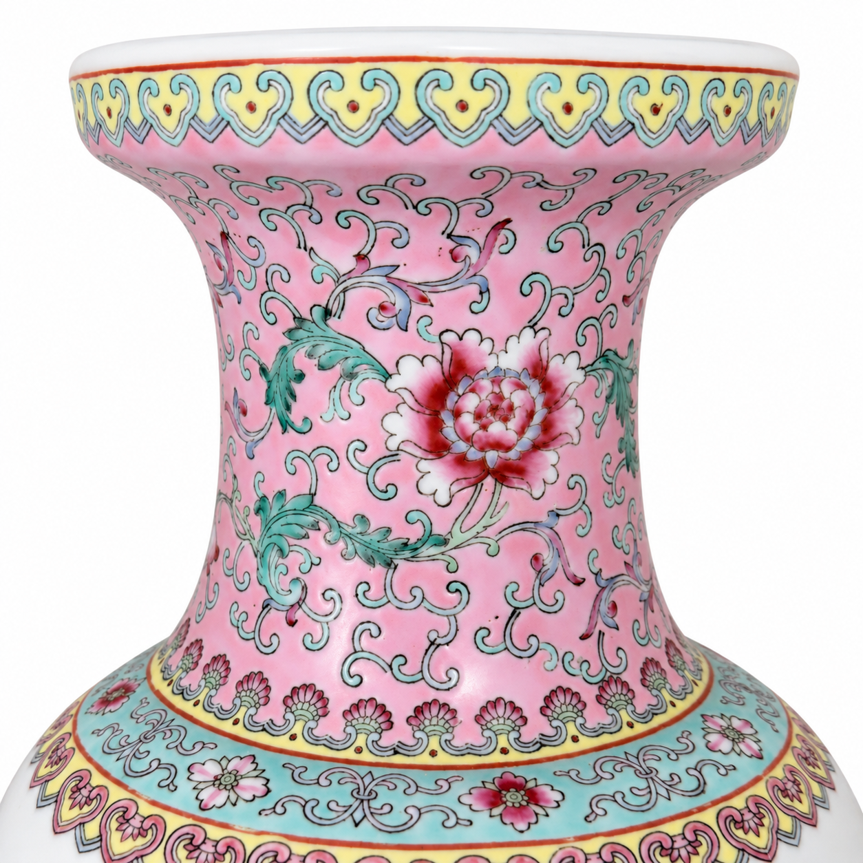 Closer view of the pink figural vase beside books and a brass candlestick on a blue chest.