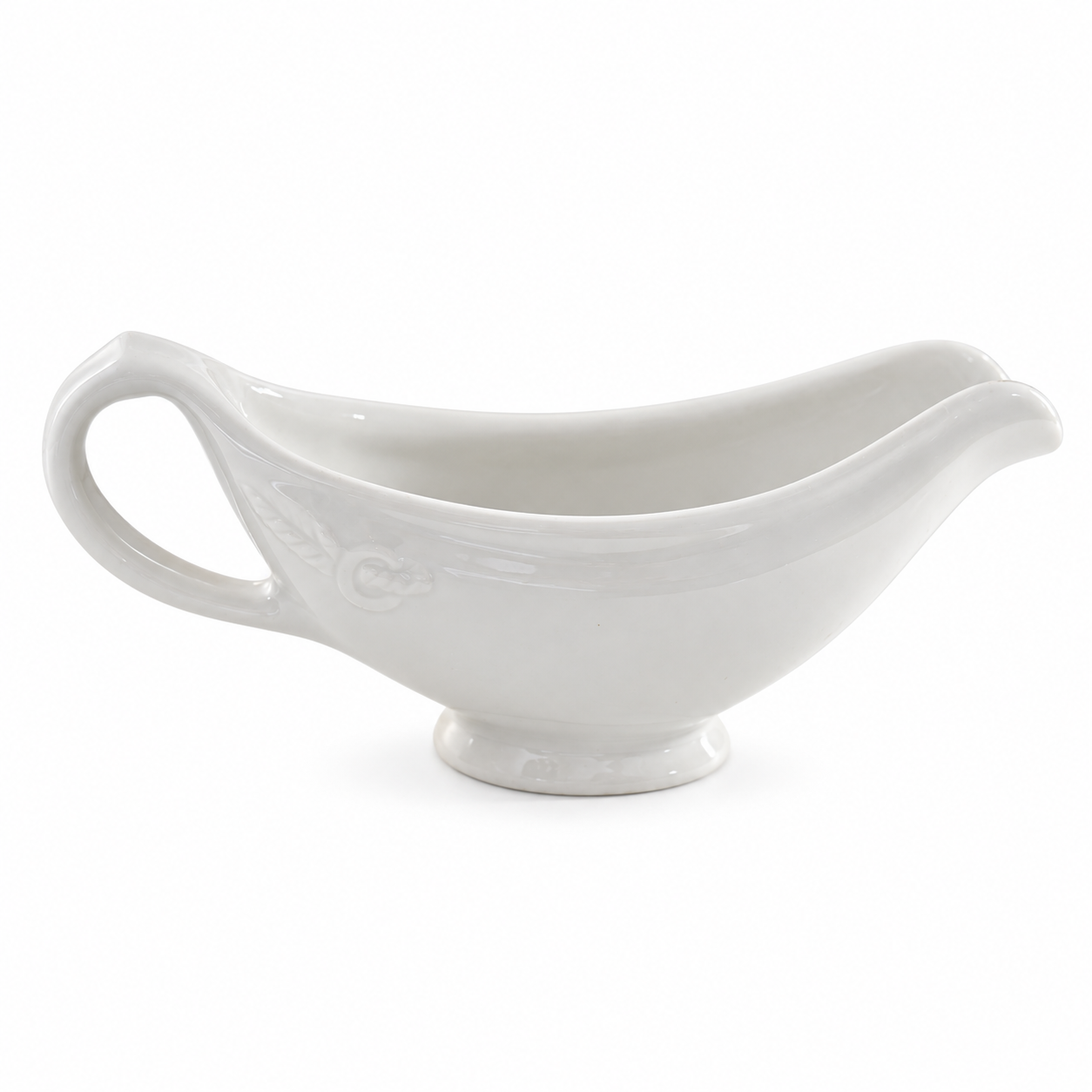 White Hall gravy boat with an embossed rose, curved handle and oval pedestal foot on a white background.