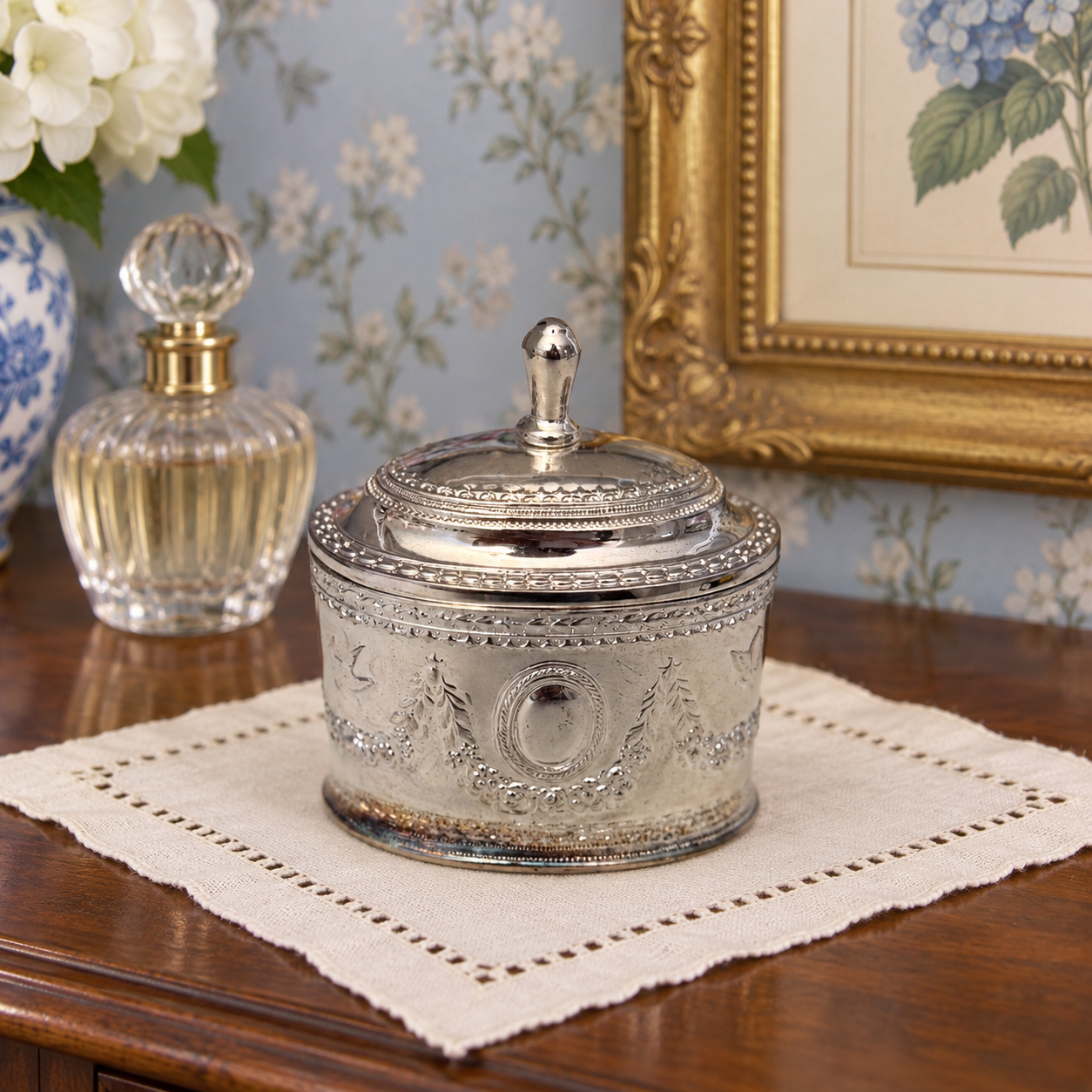 Back of the oval trinket box showing the lid hinge and decorative borders.