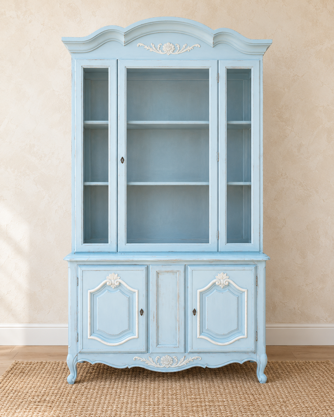 Vintage French Provincial china cabinet refinished in powder blue with white carved accents, glass doors and lower cabinet storage