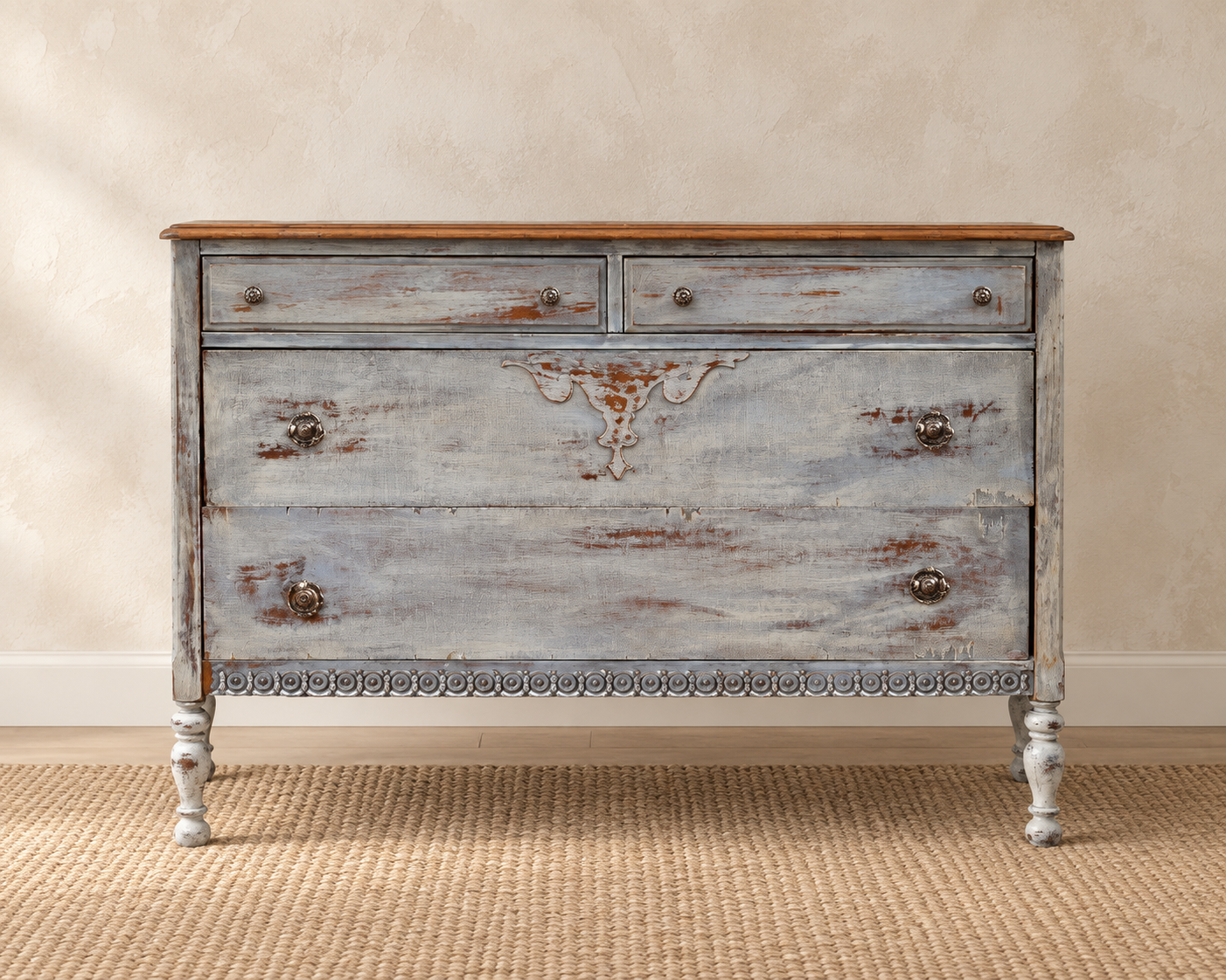 Antique chest of drawers refinished in layered gray and blue paint with distressed wood details, decorative carving and turned legs