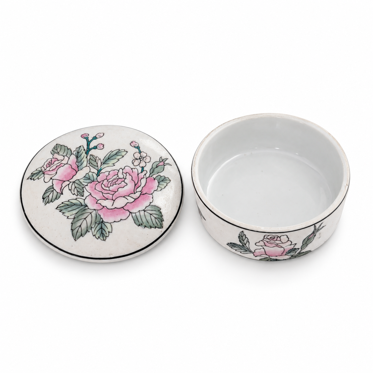Floral porcelain box opened on a blue vanity, with its lid beside it and jewelry placed inside for styling.