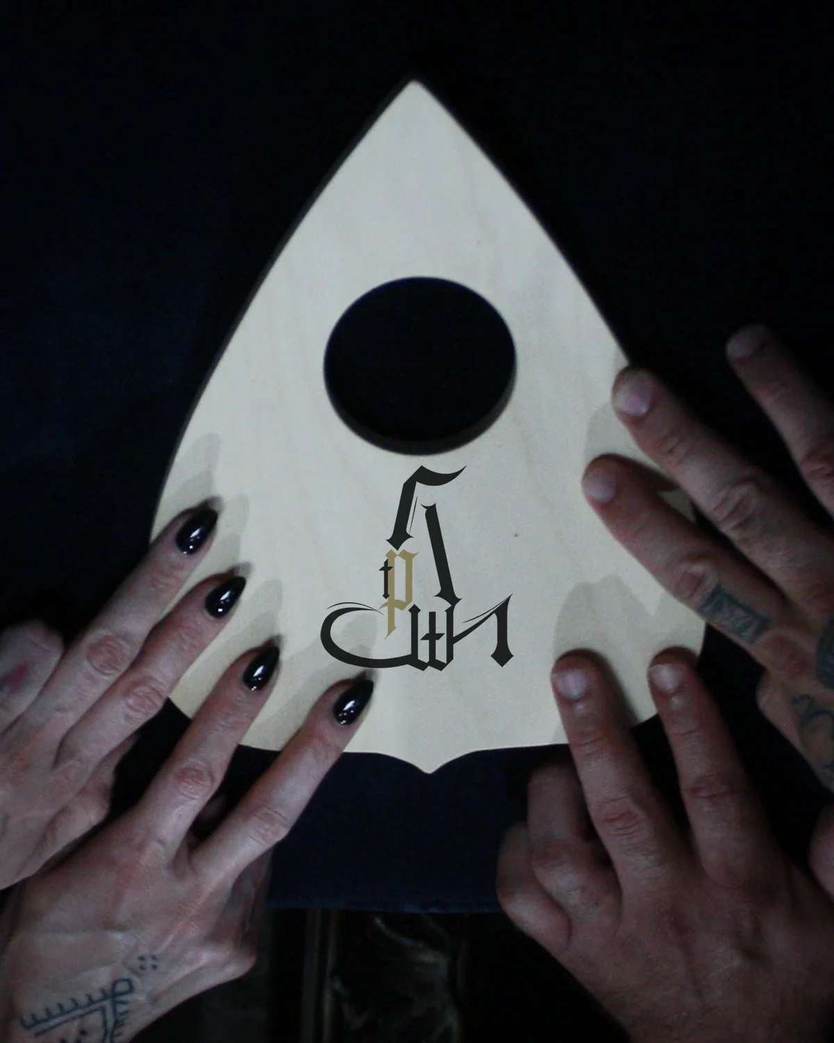 Hands holding a book with a rocket shape and a black circle in the center, featuring stylized black and gold text in Gothic font.