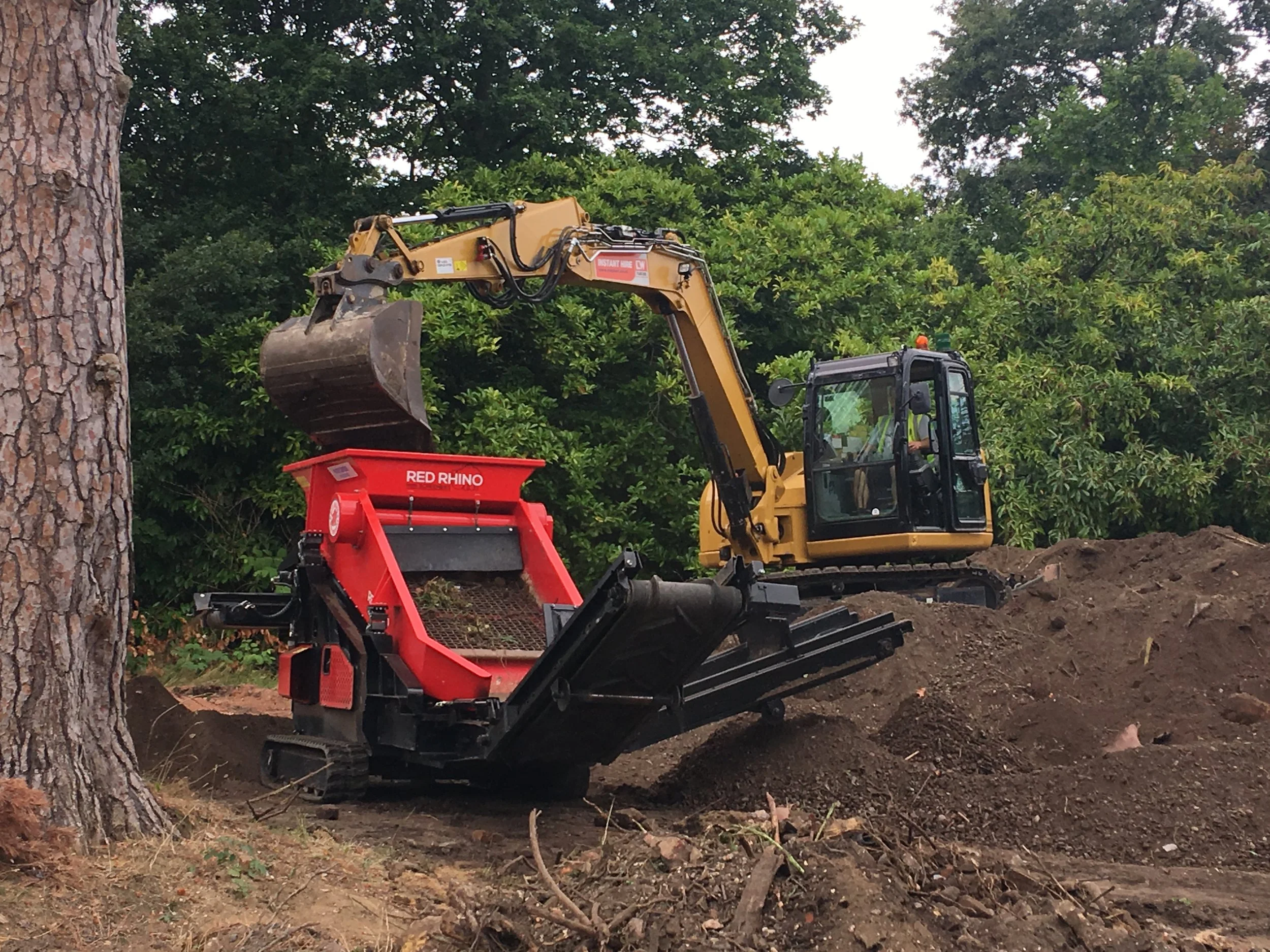 Mini excavator carrying out ground excavation during specialist invasive plant removal works