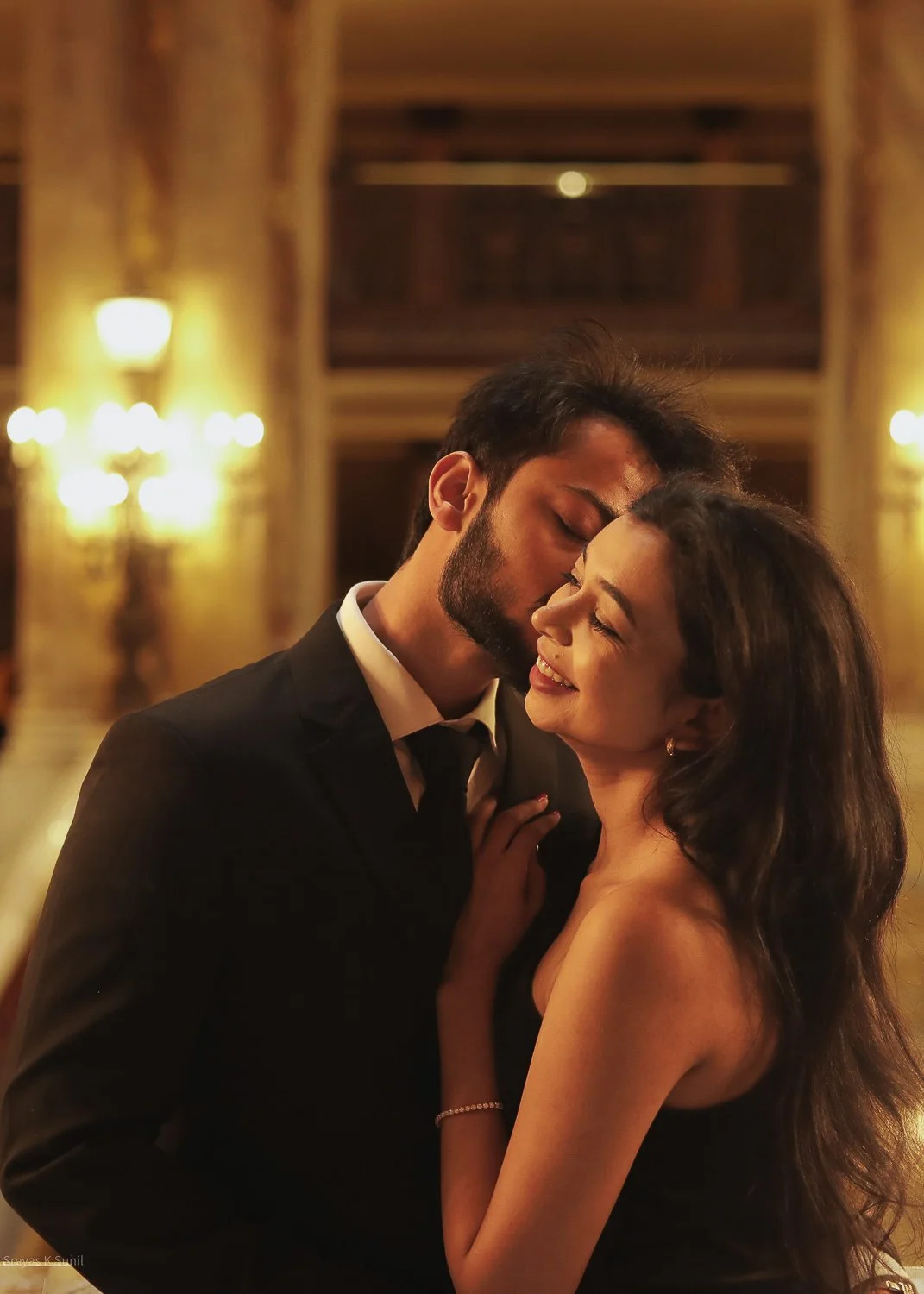 A couple dancing close together in a warmly lit elegant room, sharing a tender moment. Paris Opera