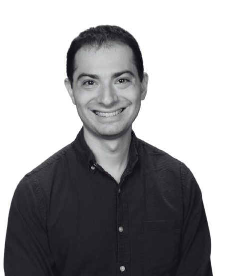 Black and white portrait of a smiling man with short dark hair wearing a button-up shirt.