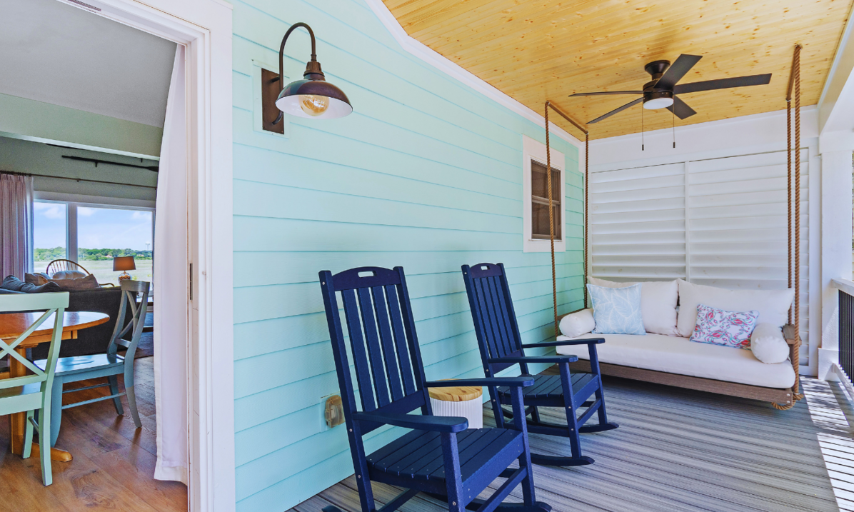 Front porch at El Sol with navy rocking chairs and a white porch swing., directly off the dining room