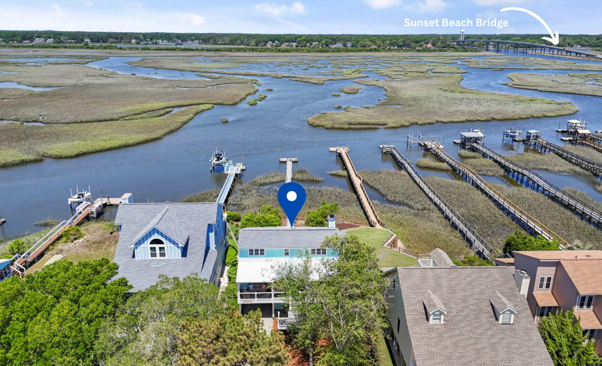 Aerial view of El Sol on the marsh with docks and the Sunset Beach Bridge in the distance.