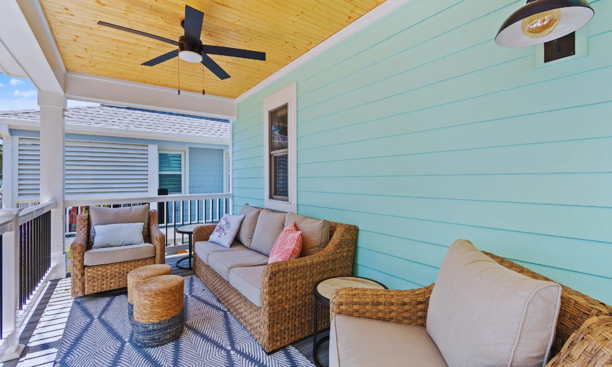 Outdoor front porch at El Sol with wicker sofa and chairs under a ceiling fan