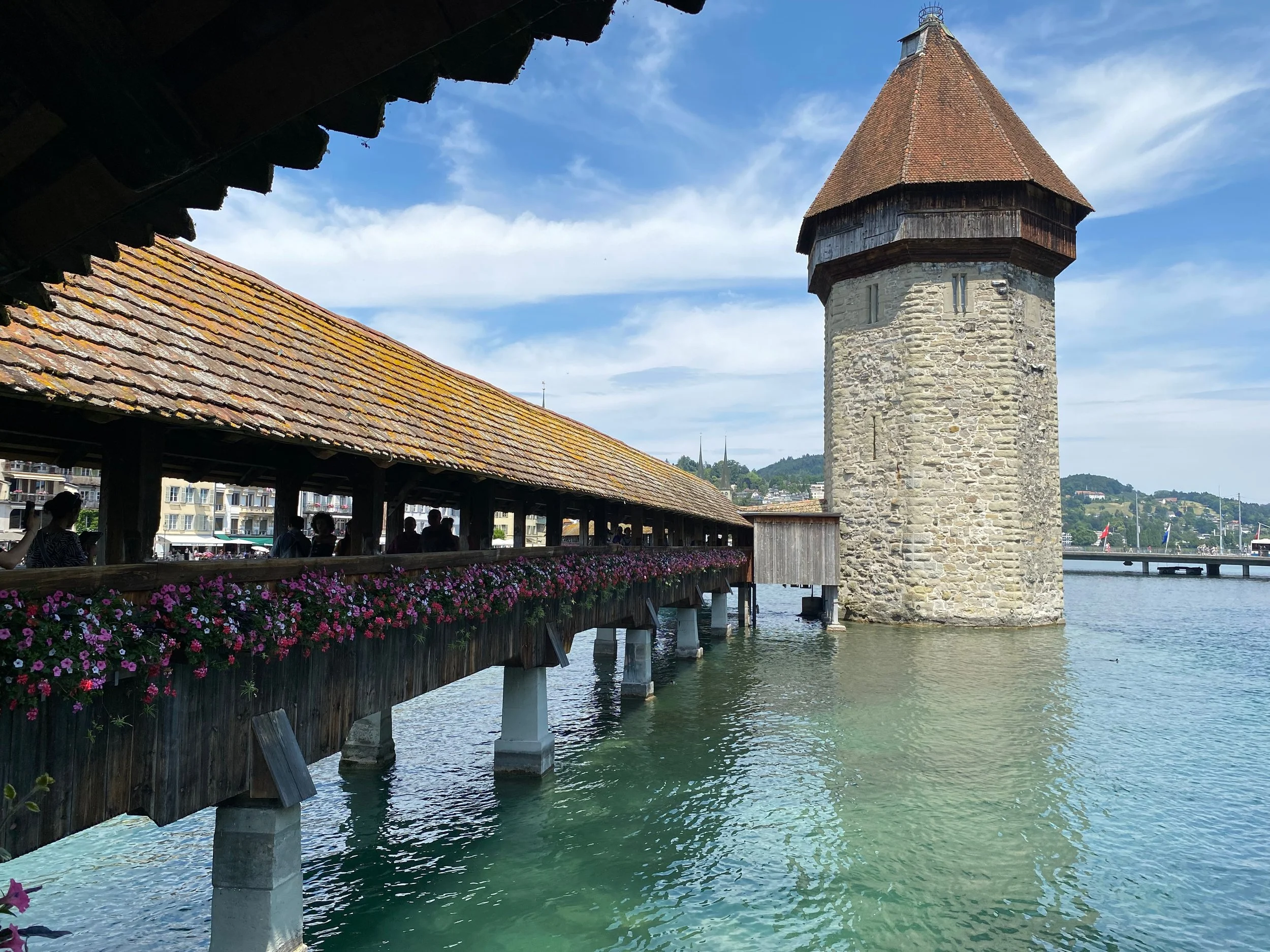 Historic Chapel bridge, stone tower and wooden walkway over water in Lucerne, Switzerland.
