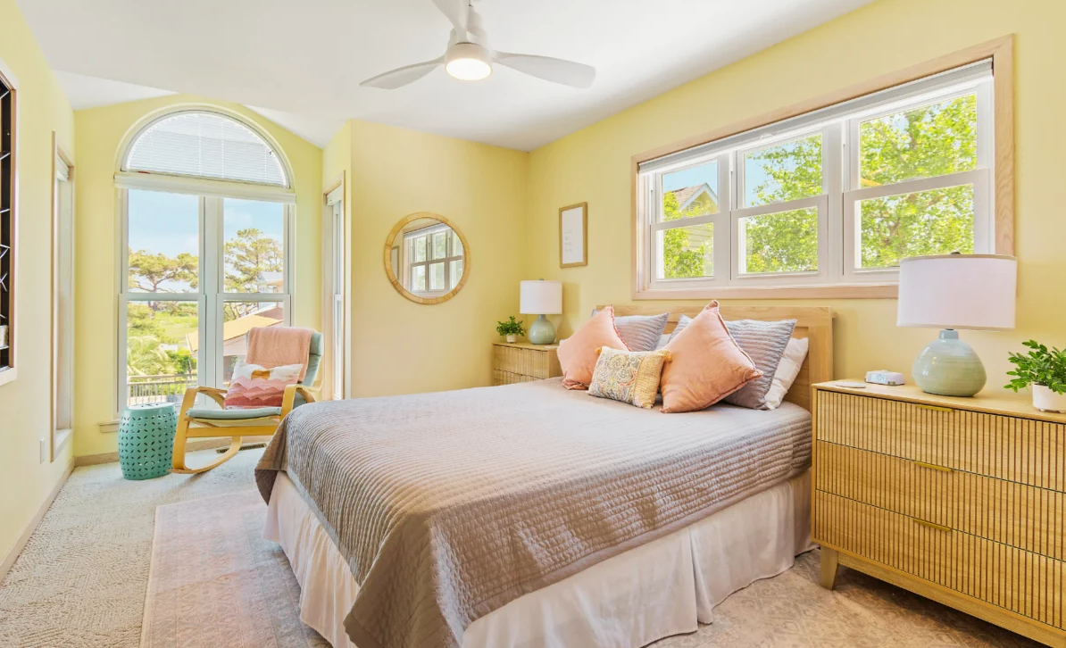 Queen Upstairs Bedroom at El Sol with a window seating area and pastel-colored bedding.