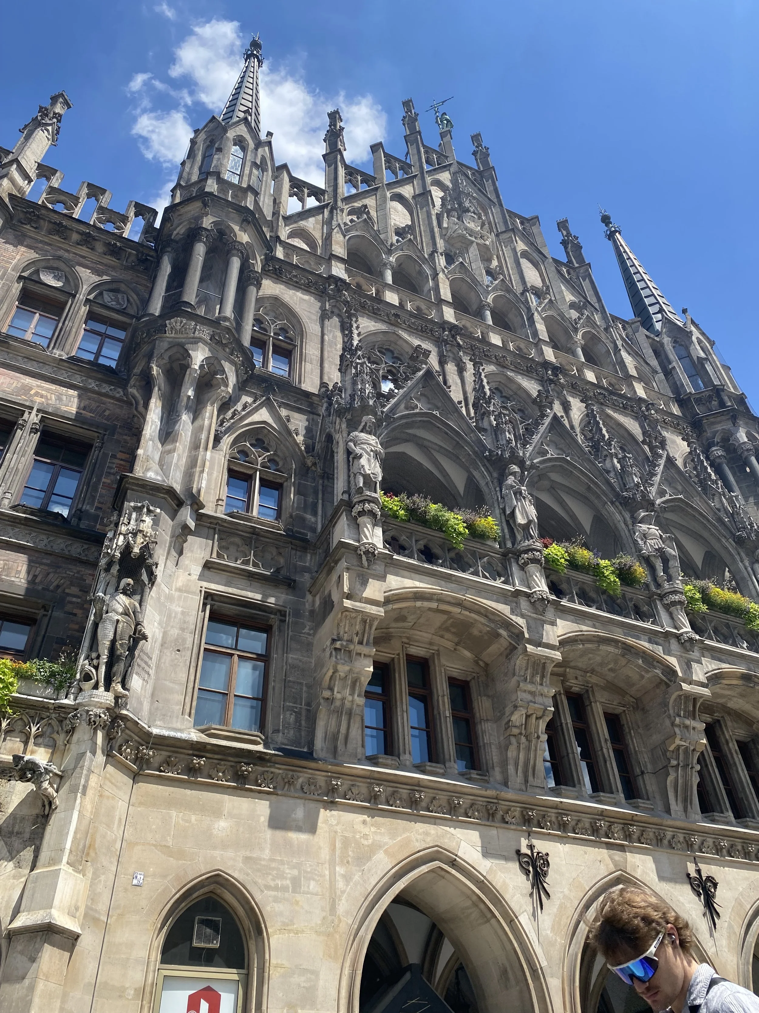 Gothic-style building with ornate spires and stone carvings in Munich, Germany.
