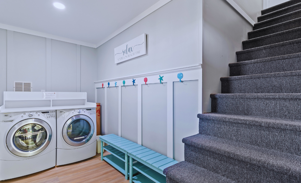 Laundry room at El Sol with a washer and dryer, drop zone area and a staircase leading upstairs.
